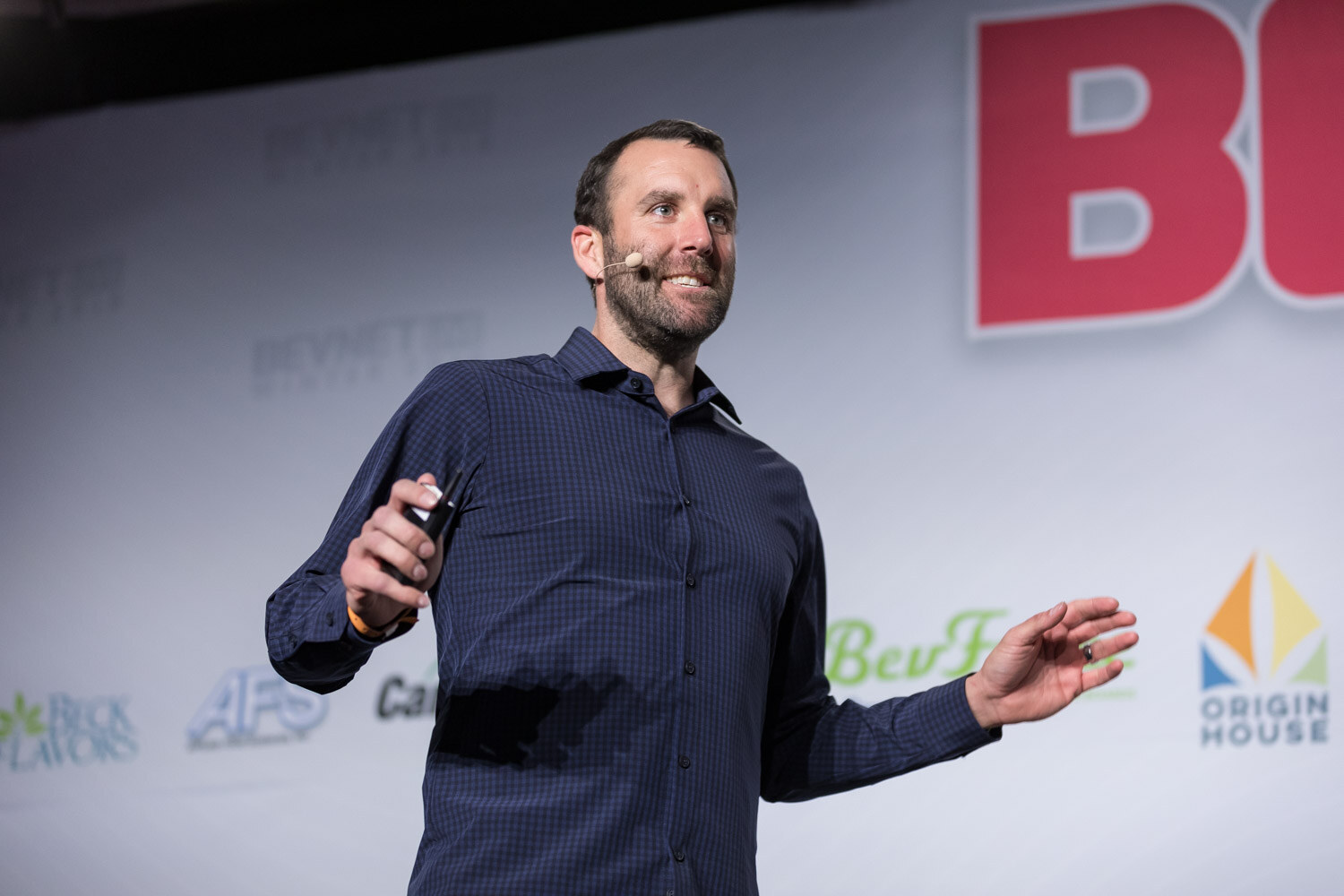 Man in a dark button-up shirt gesturing in front of a BevNET Live backdrop.