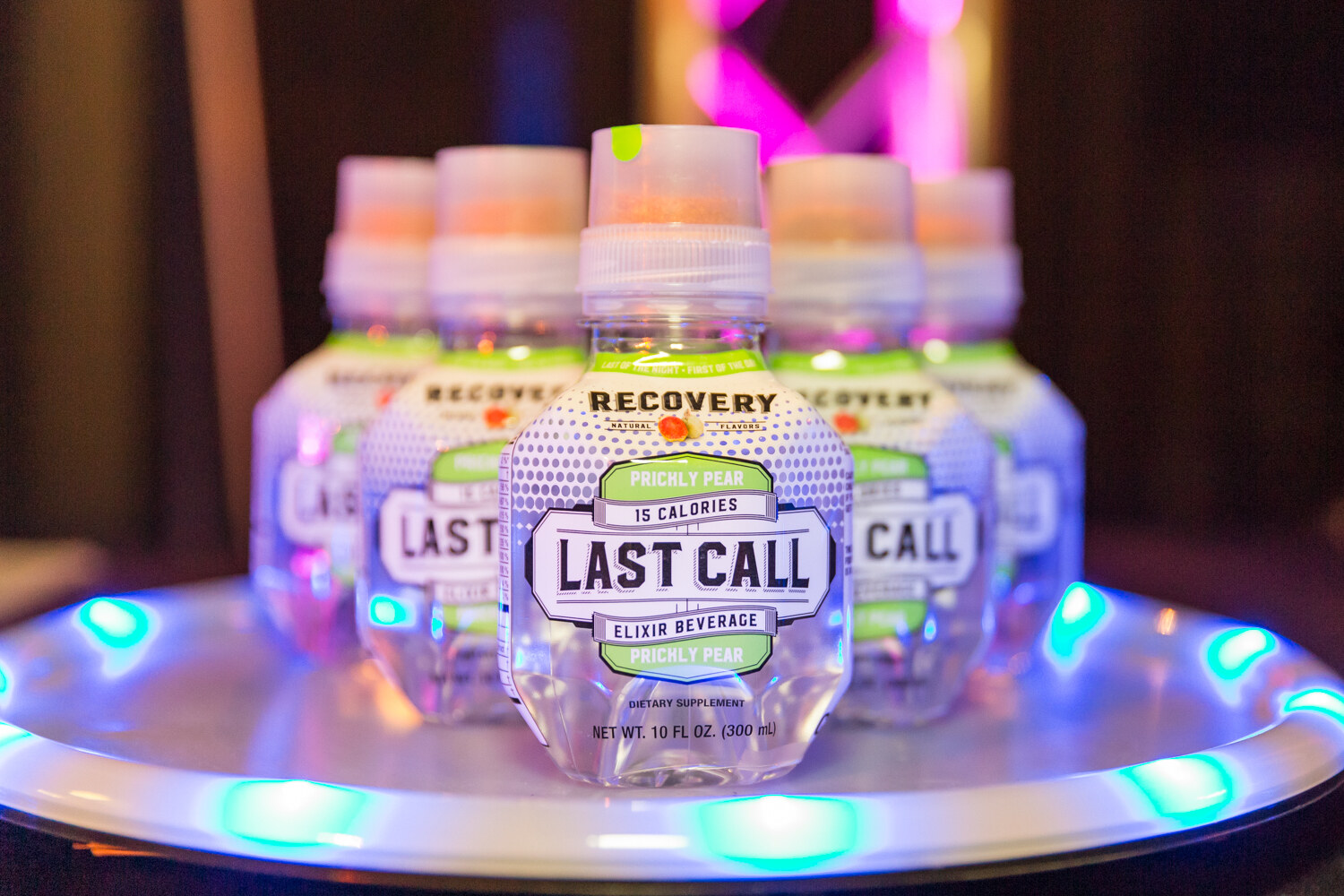 Small bottles labeled Last Call on a tray with blue and green lights.