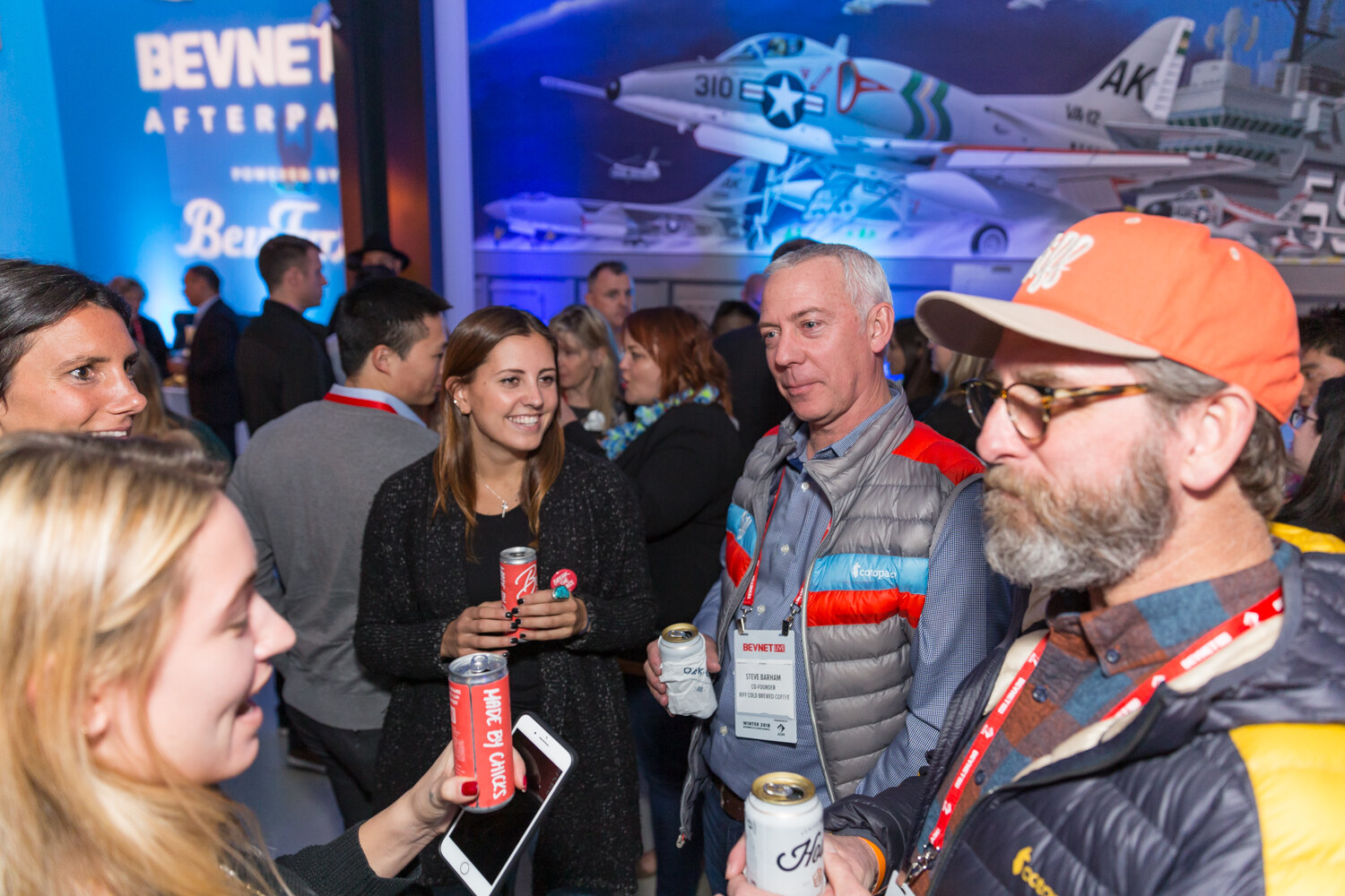 Group of attendees holding cans in front of a BevNET Live Afterparty sign.