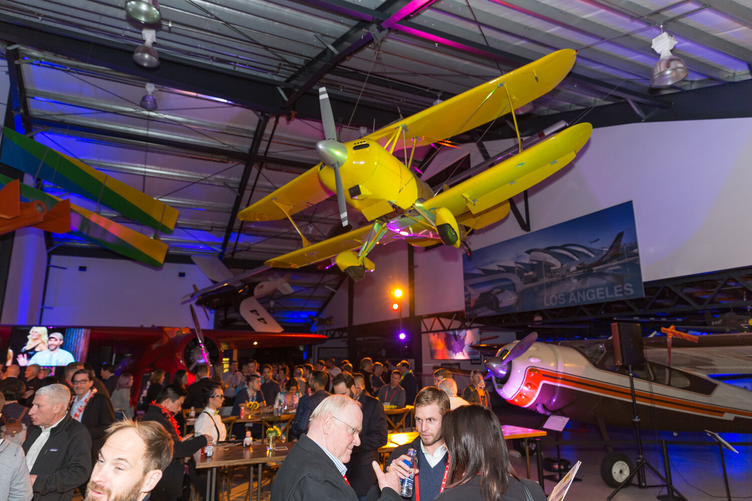 Yellow biplane suspended from the ceiling above guests seated at wooden tables.