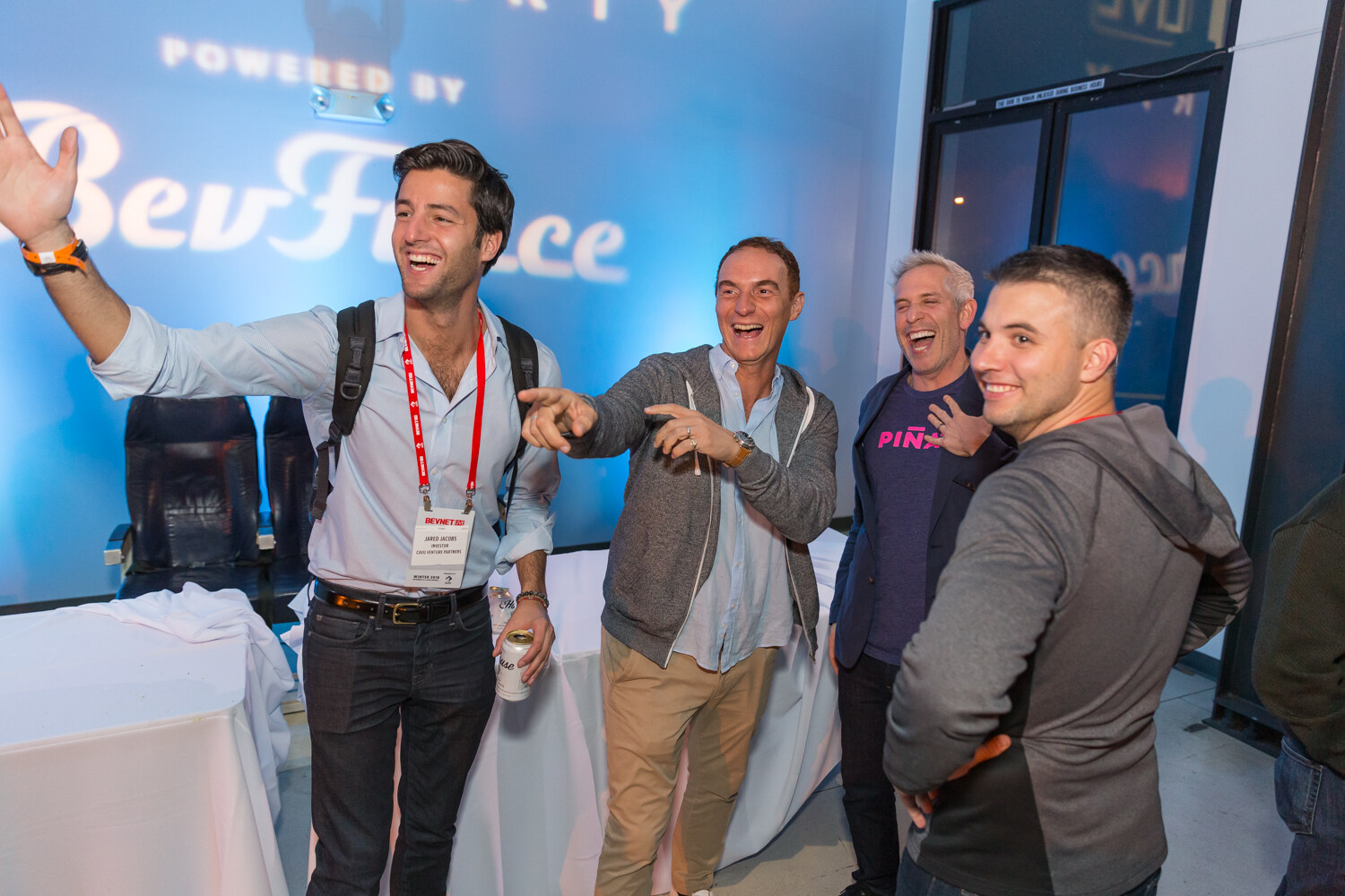 Four men celebrating in front of a blue BevForce backdrop, one pointing at the camera.
