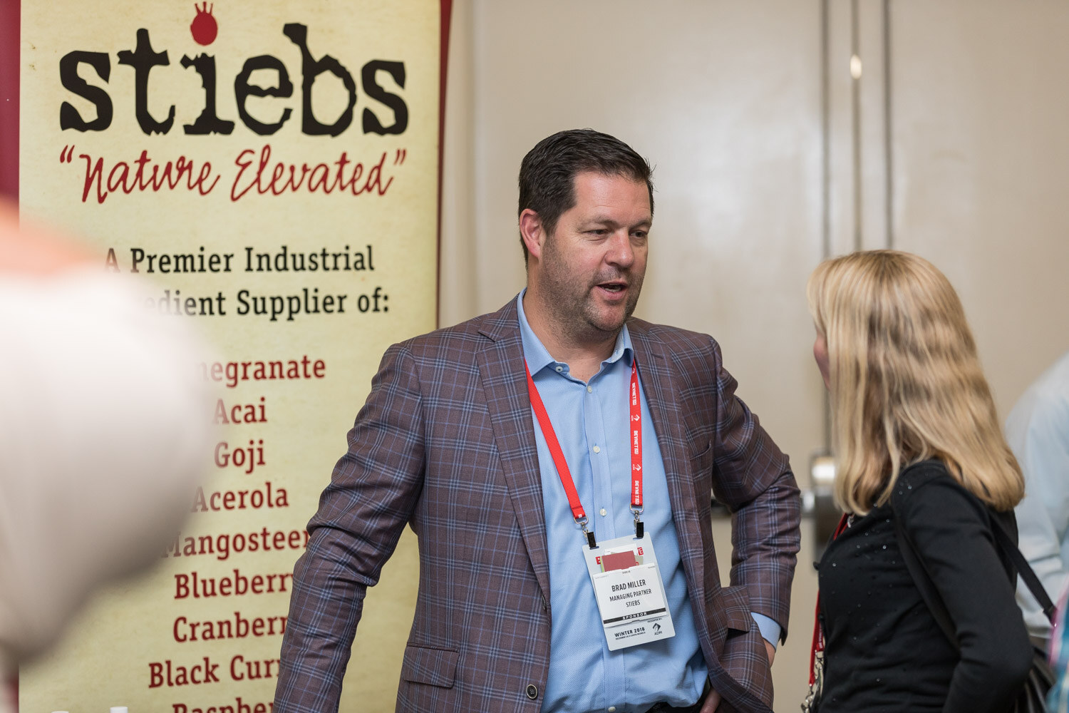 Man in a plaid blazer in front of a Stiebs Nature Elevated banner.