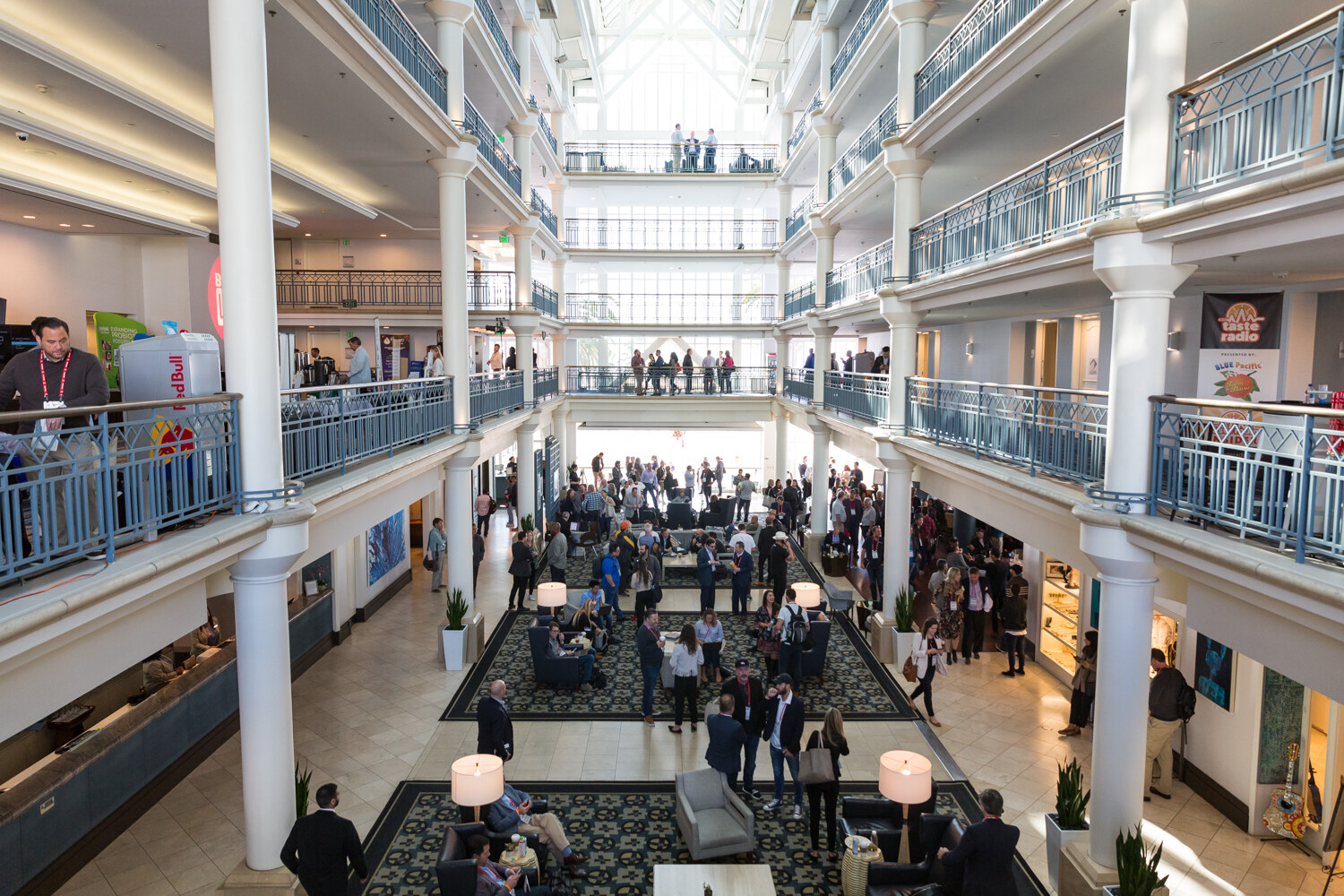 View down into a multi-story atrium with attendees mingling on the lower floor.