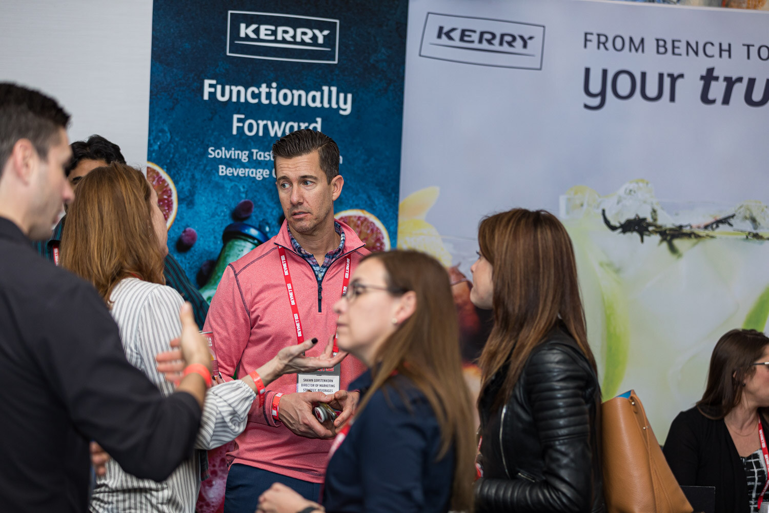 Several attendees chat in front of Kerry banners reading Functionally Forward and From bench to bottle.