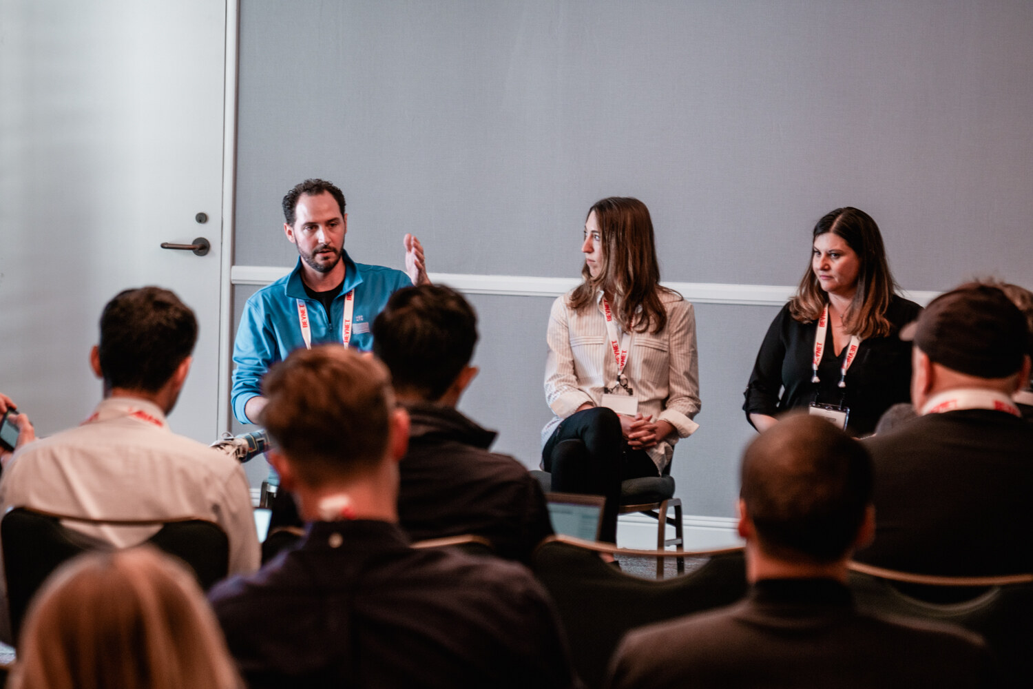 Three panelists with BevNET badges sit at the front of a small meeting room while seated attendees fill the foreground.