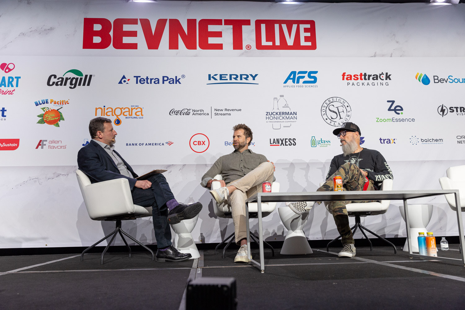 Three people sit on a stage under a BevNET Live backdrop.