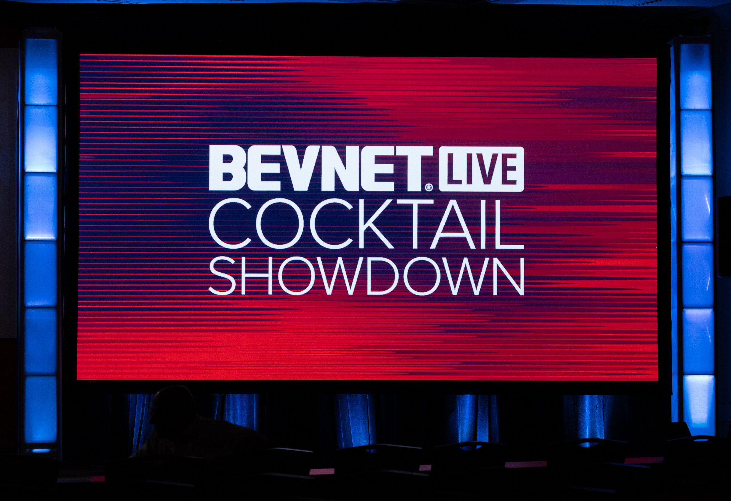 Large screen reading BevNET Live Cocktail Showdown in white letters on a red background.