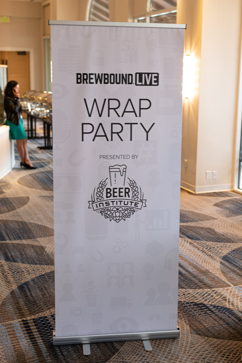 A white standing banner reading Brewbound Live Wrap Party presented by Beer Institute in a hotel hallway.