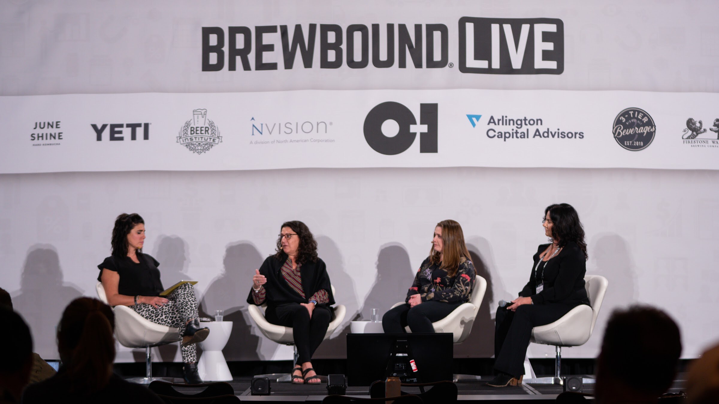 Four women sit on a wide stage under the Brewbound Live banner with sponsor logos, with audience heads in the foreground.