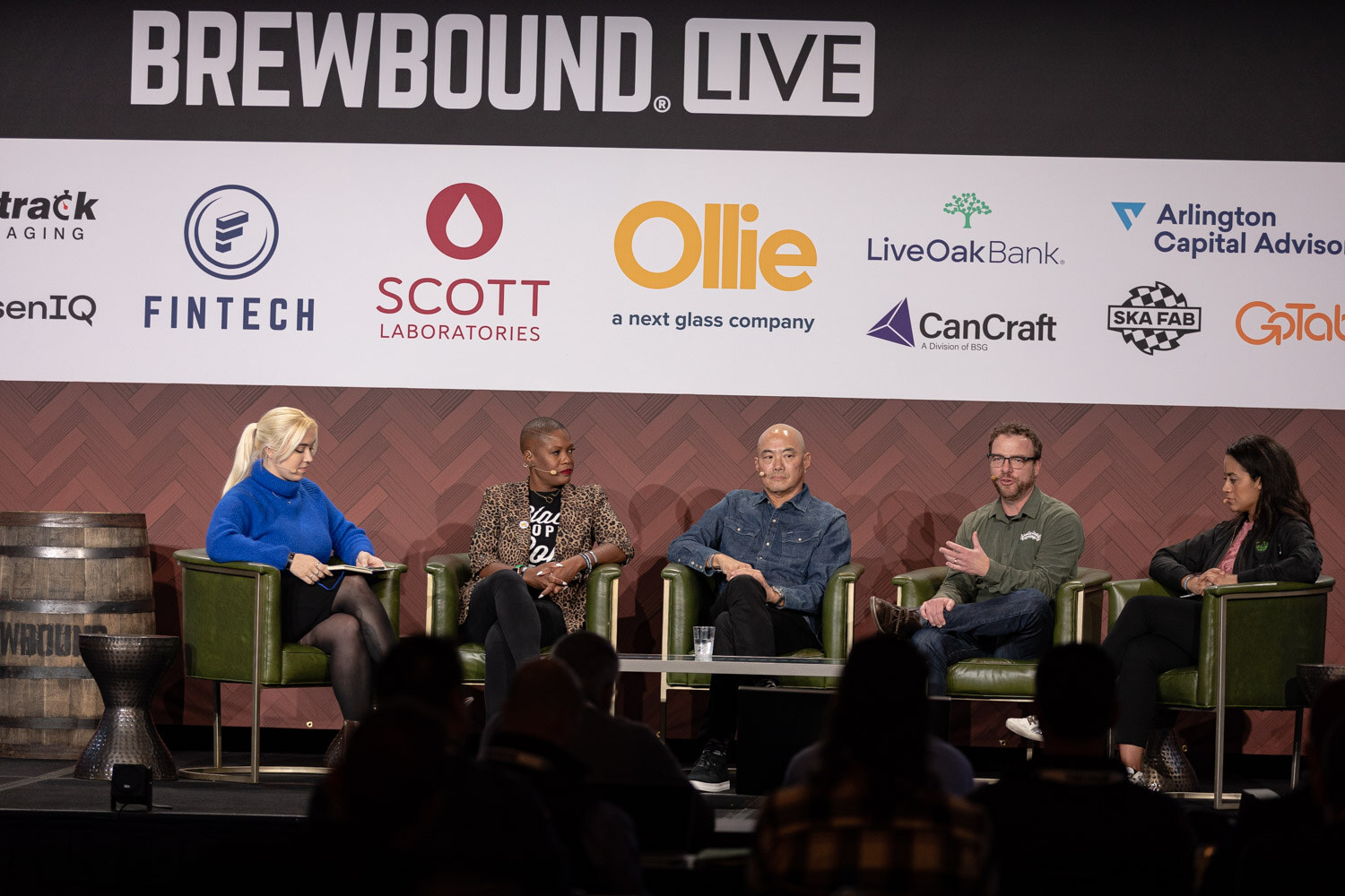 Wide view of five people seated in green armchairs on the Brewbound Live stage.