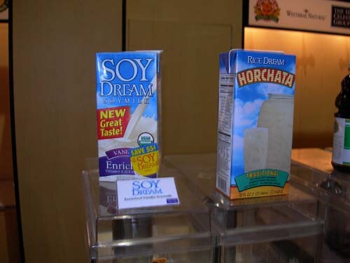Two cartons on a clear acrylic display: Soy Dream soy milk on the left and Rice Dream Horchata on the right, with a small Soy Dream card in front.