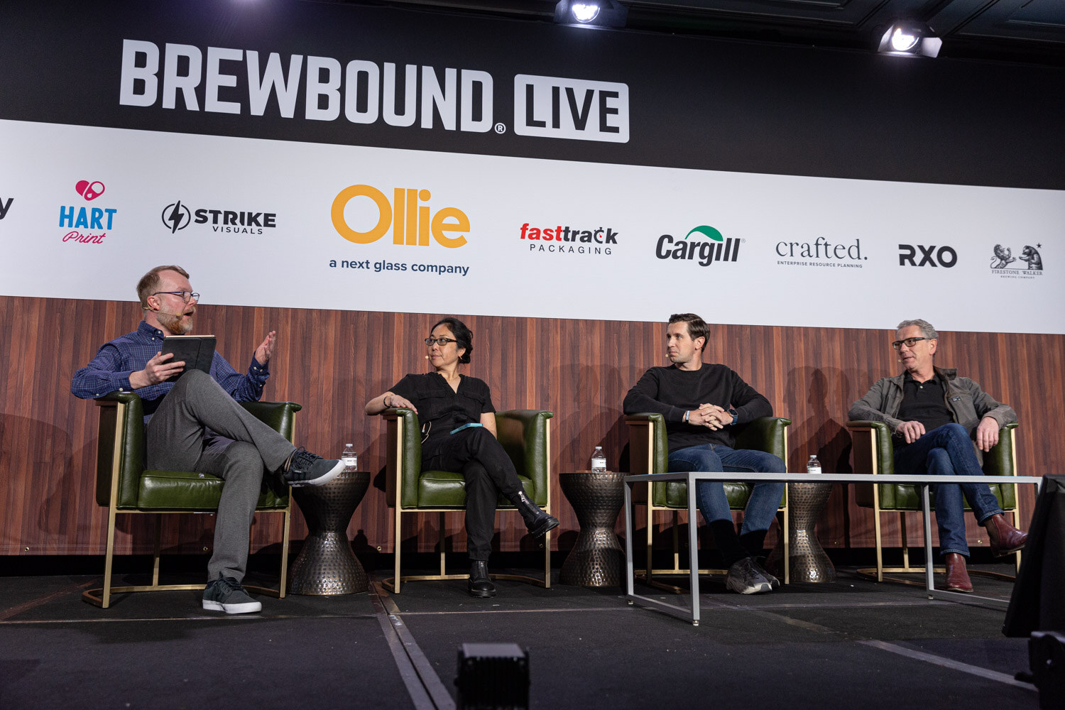 Four people sit in green armchairs on stage under a Brewbound Live banner with sponsor logos.