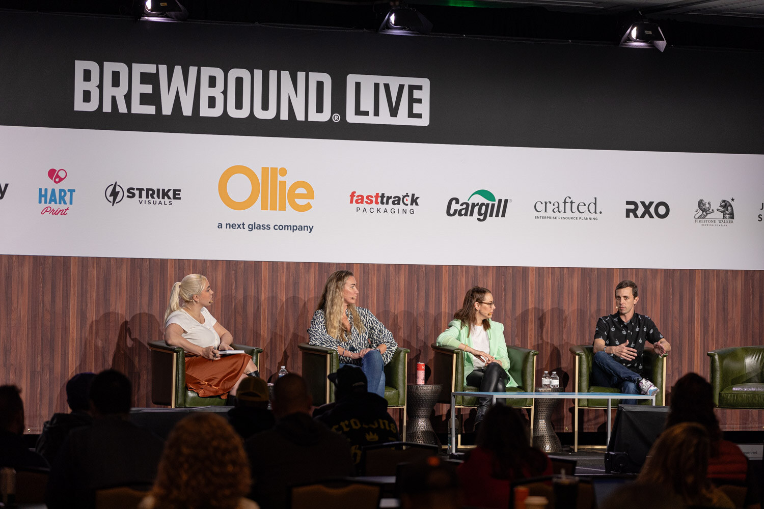 Four people sit on stage beneath the Brewbound Live banner with audience members in the foreground.