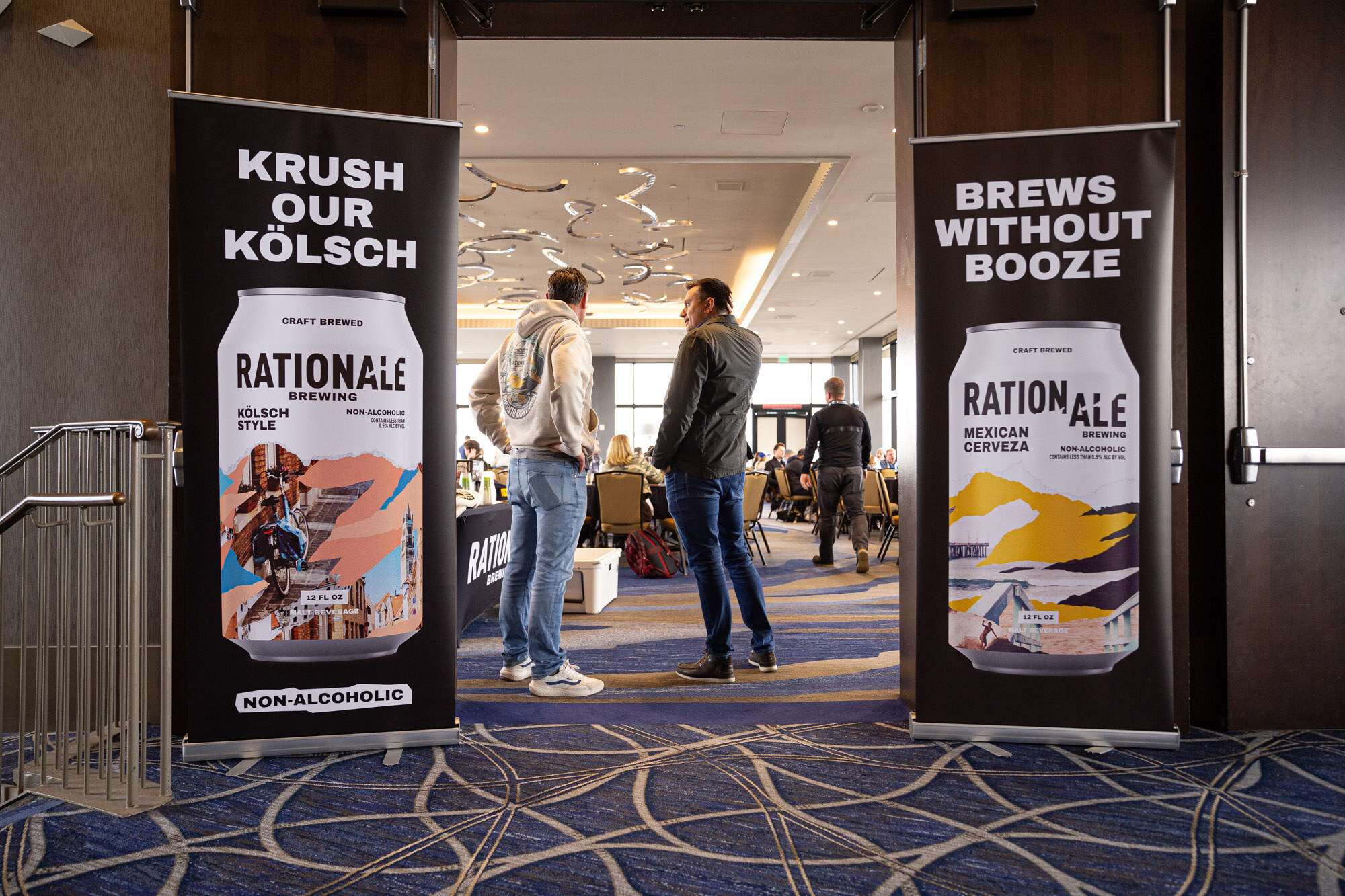 Two black banners for Rationale Brewing non-alcoholic Kolsch and Mexican cerveza stand at a doorway.