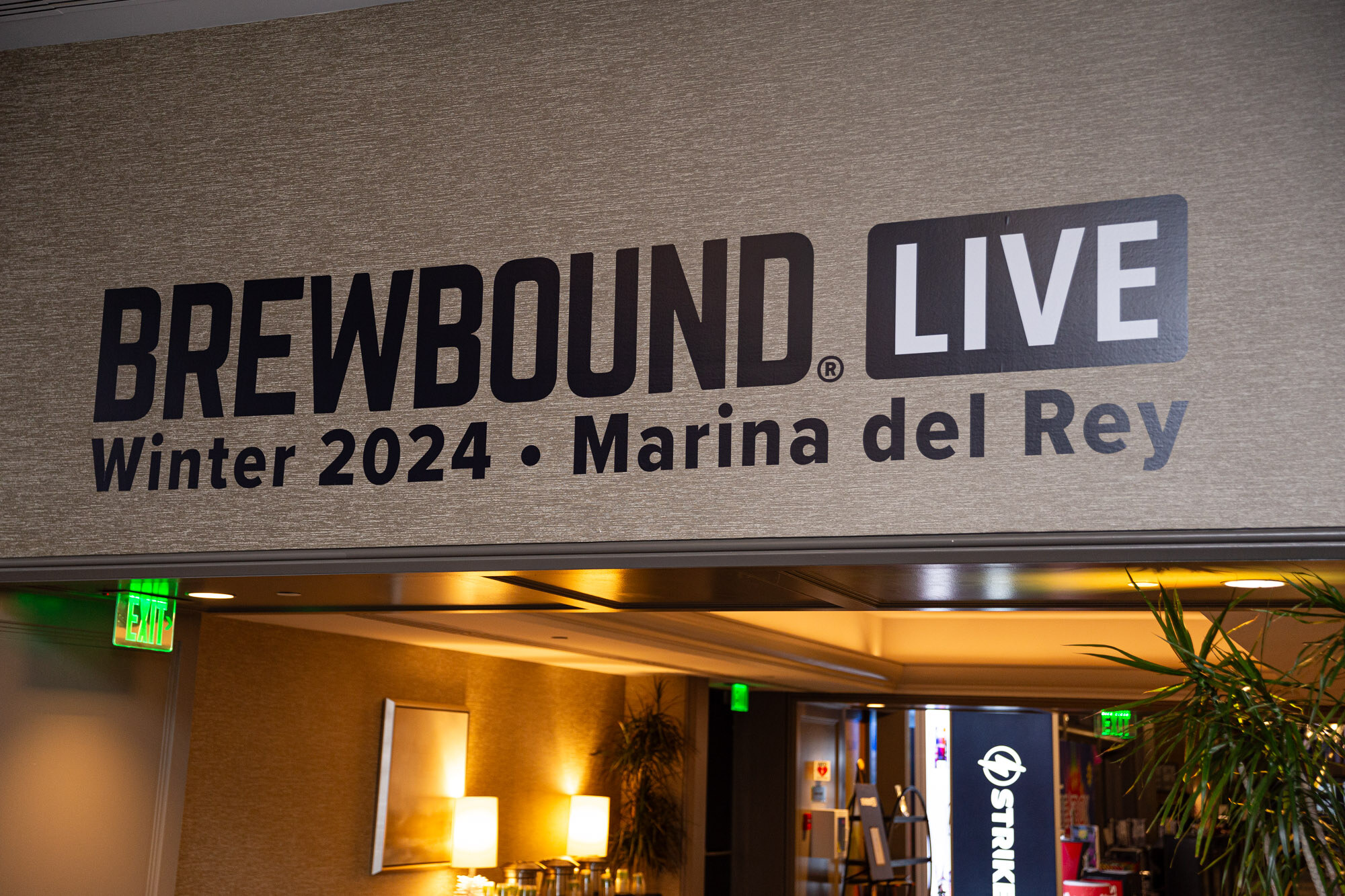 A sign reading Brewbound Live Winter 2024, Marina del Rey, above a doorway.
