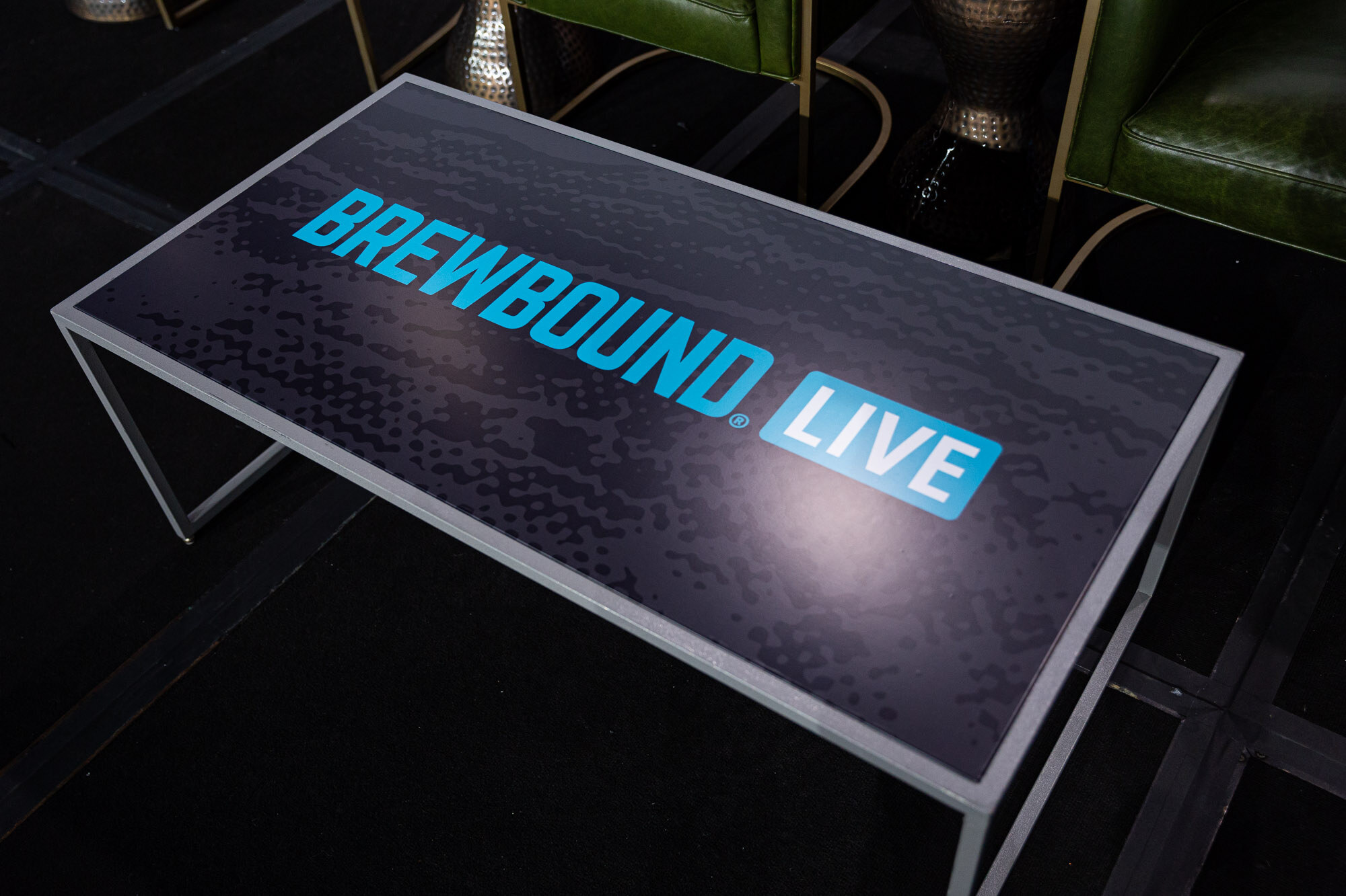 A dark table top printed with a blue Brewbound Live logo.