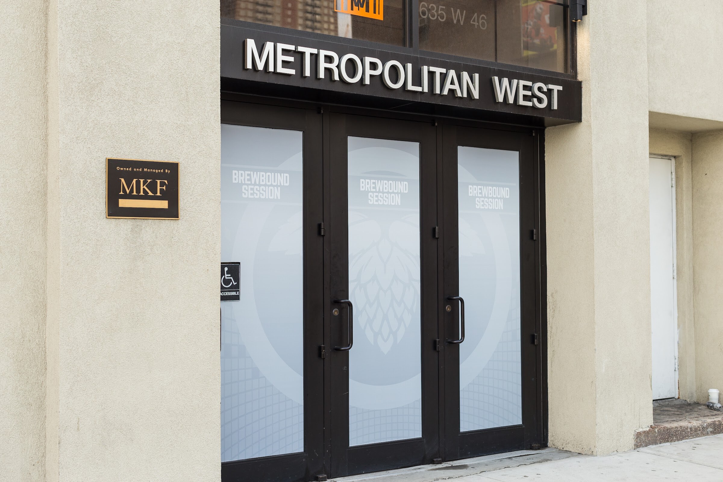 Black double doors with frosted Brewbound Session hop-cone graphics under a Metropolitan West sign reading 635 W 46.