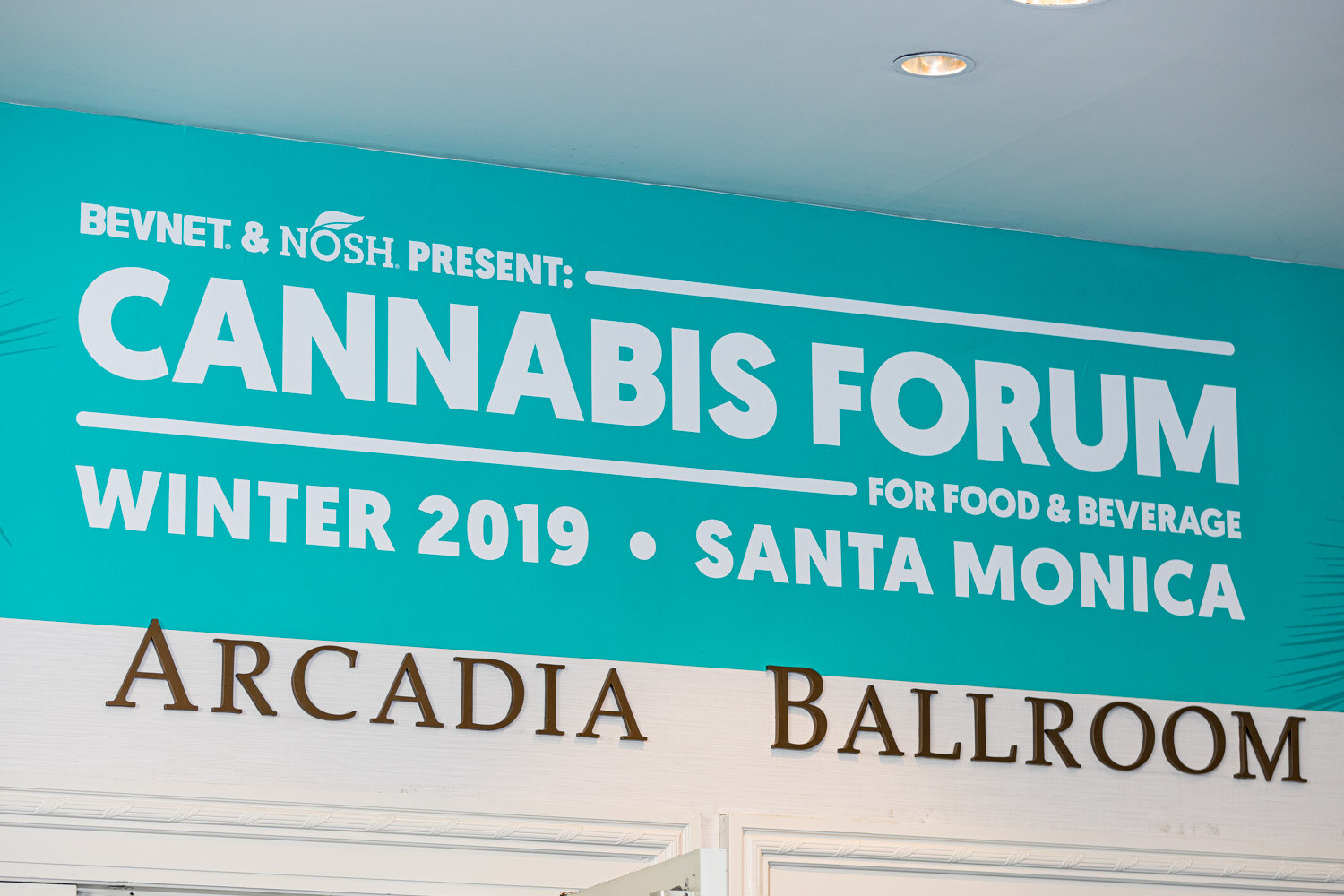 A teal sign reading BevNET & Nosh present Cannabis Forum for Food & Beverage, Winter 2019, Santa Monica sits above brass letters spelling Arcadia Ballroom.