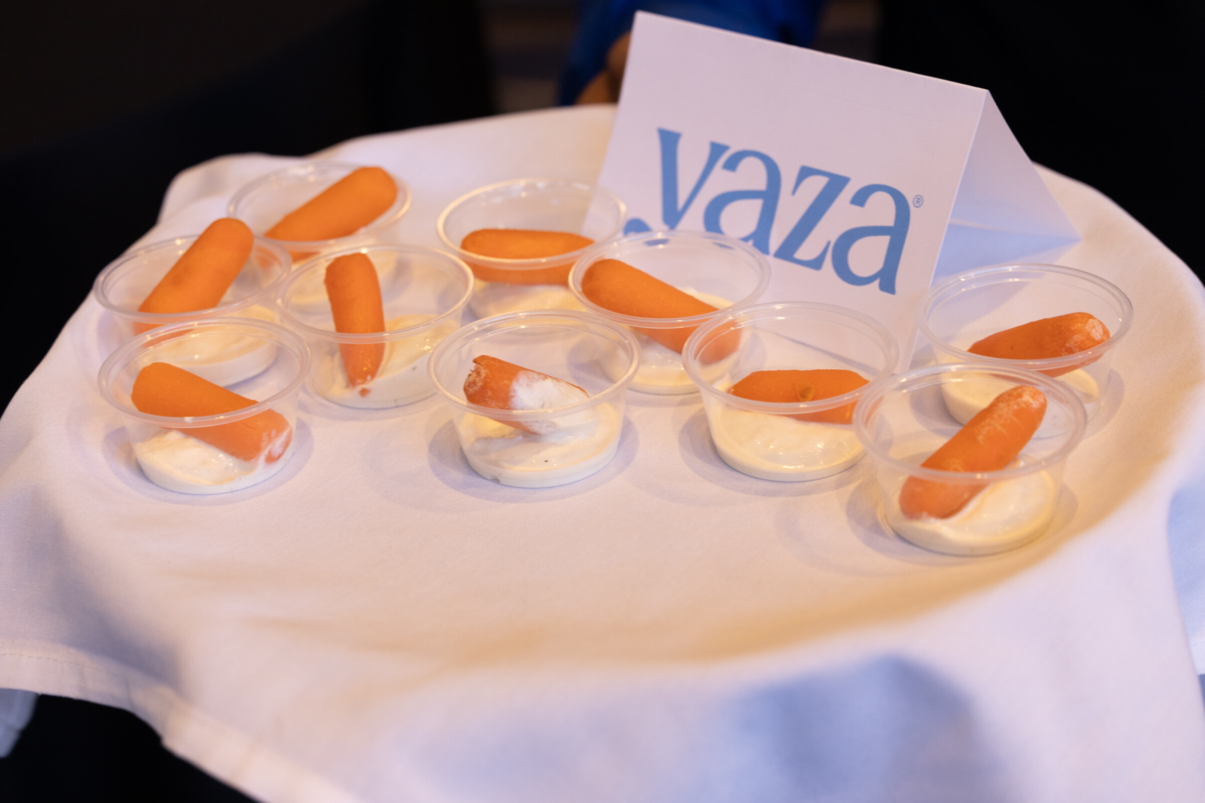 A tray of small cups with carrot sticks in dip and a card reading Yaza.