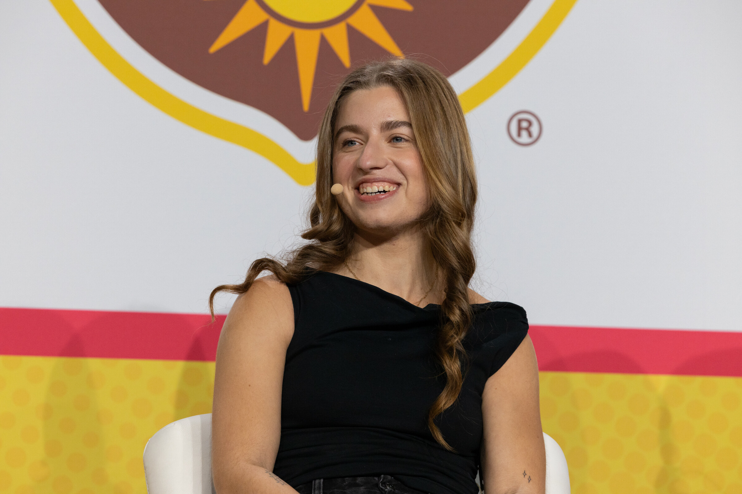 A smiling woman with long wavy hair in a black top in front of a California Walnuts logo.