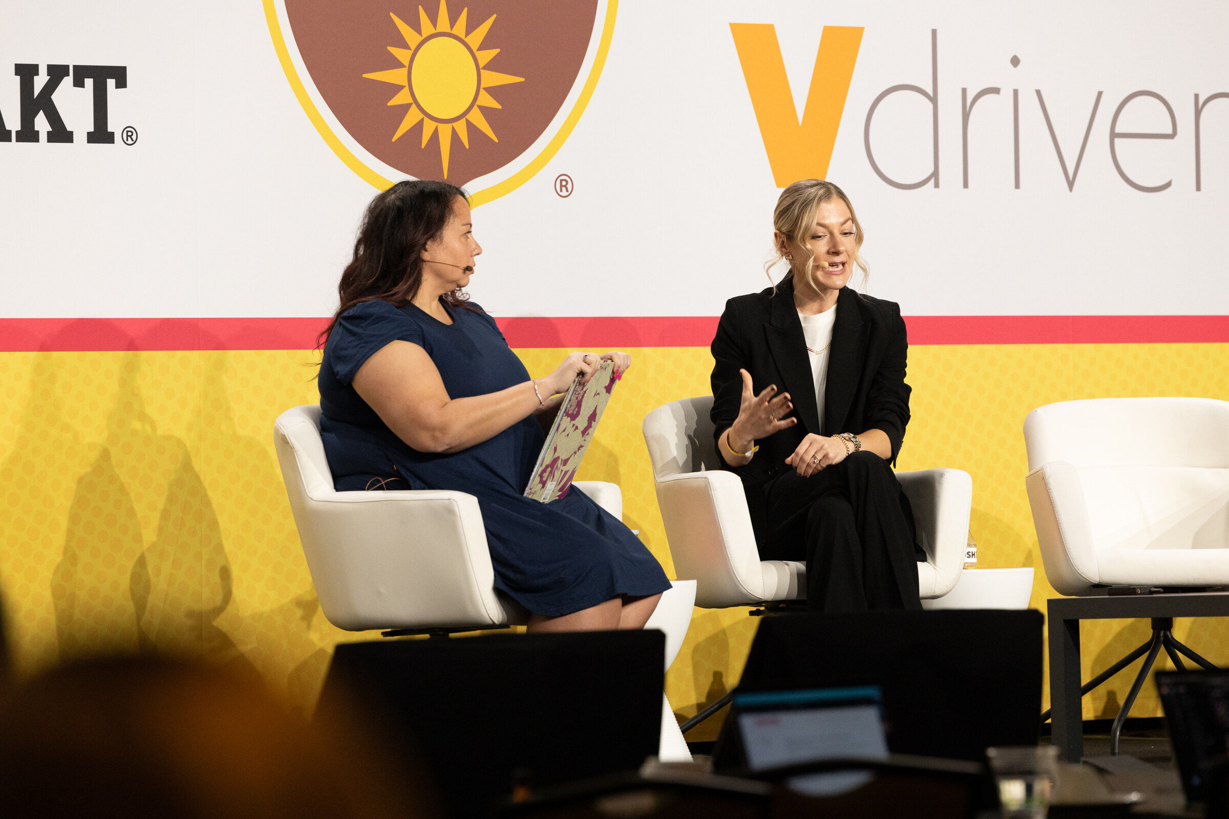 Two women seated in white chairs on stage in front of California Walnuts and Vdriven signs.
