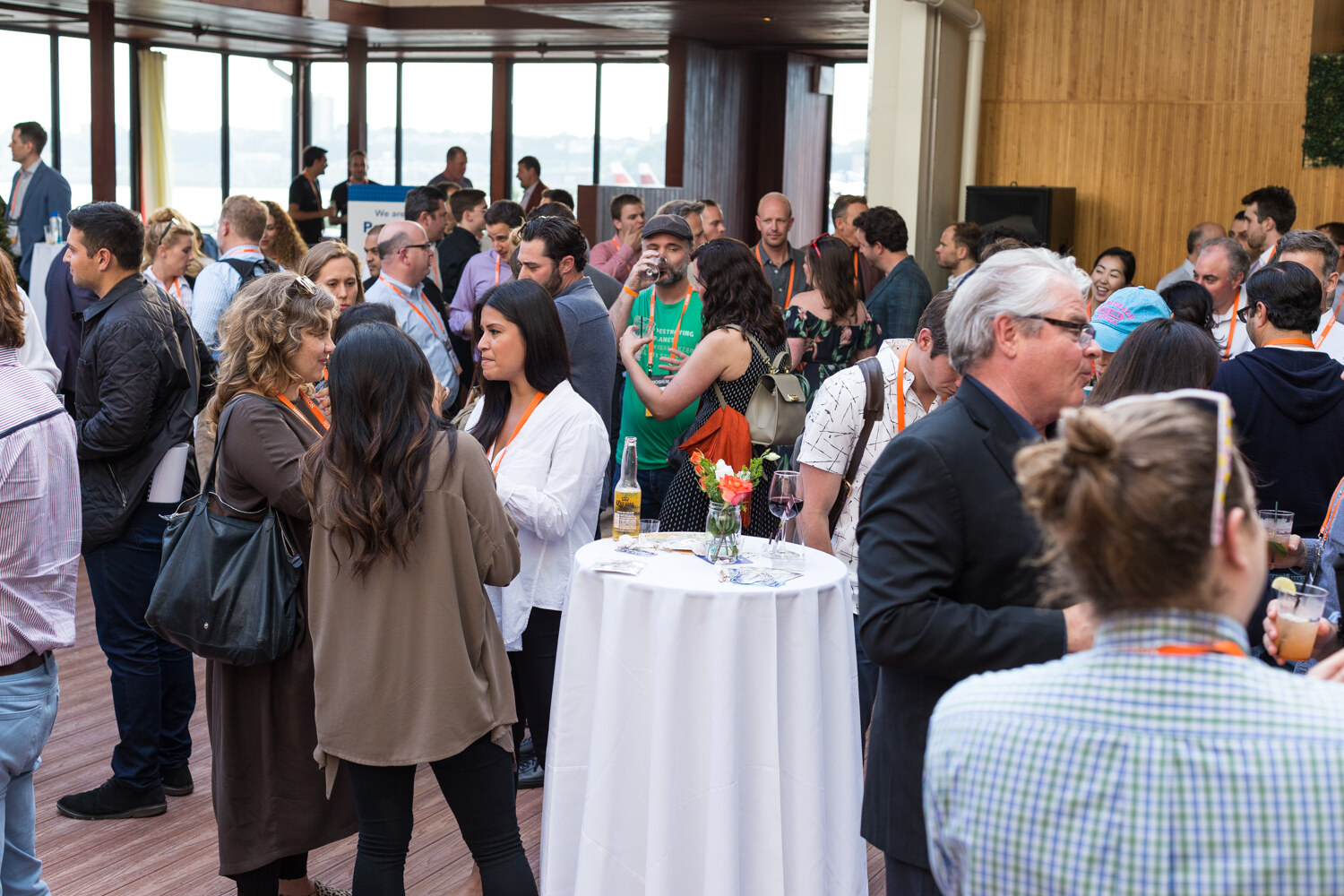 Guests mingle around high-top tables on the rooftop terrace at the Nosh Live afterparty.