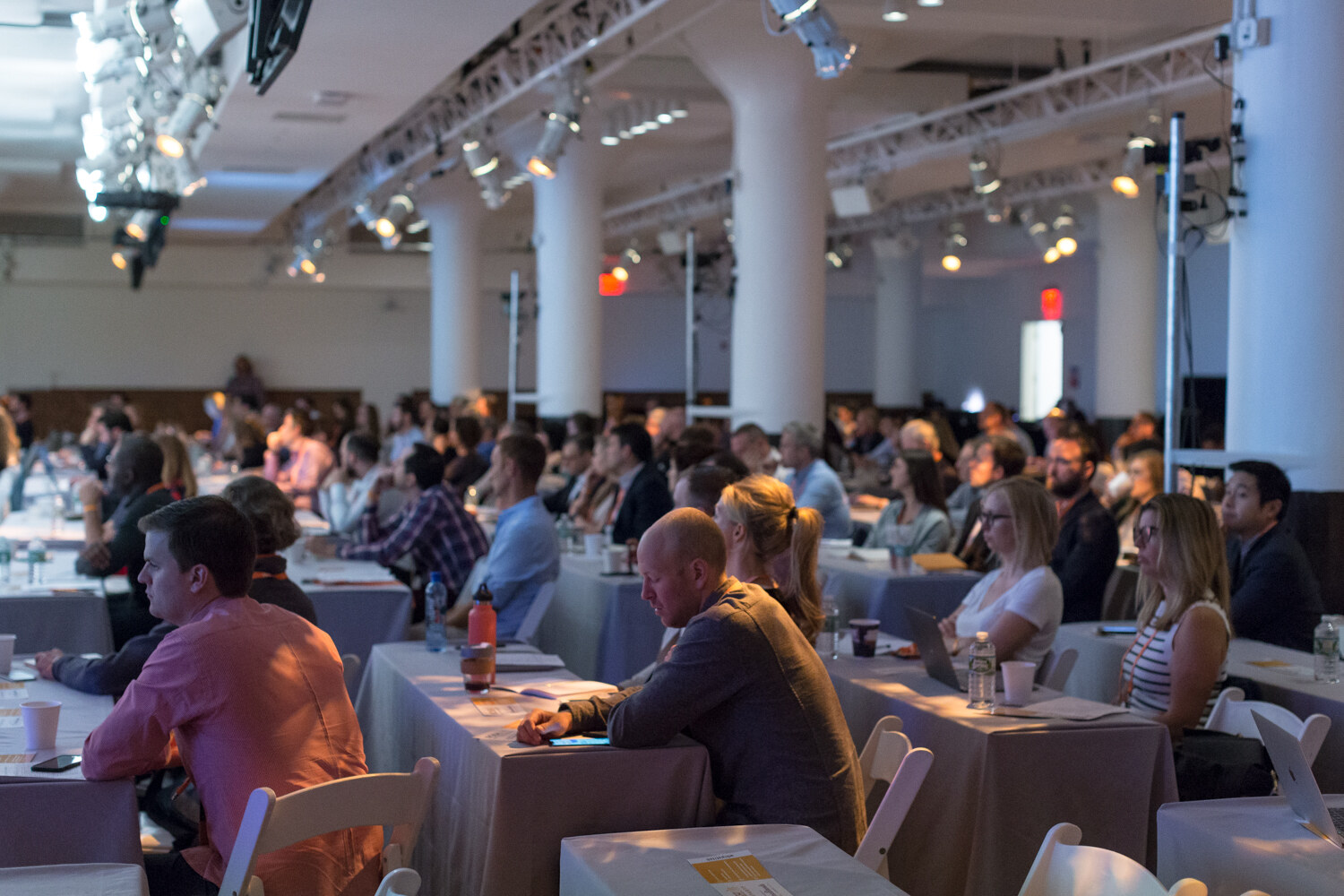 Attendees seated at long tables in the Nosh Live ballroom during the morning program.