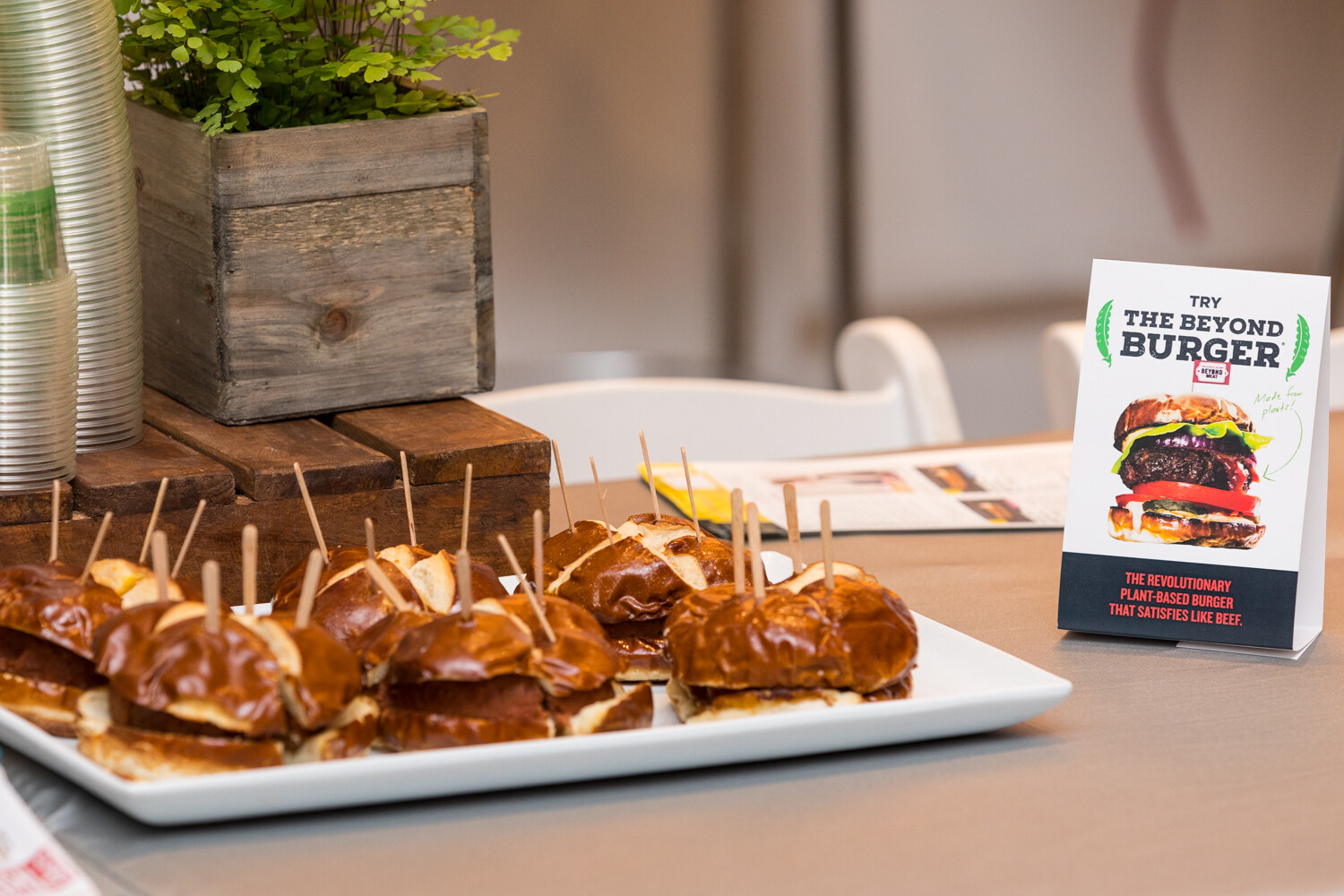 Pretzel-bun sliders on a platter beside a tent card for the Beyond Burger at the Sampling Experience and Expo.