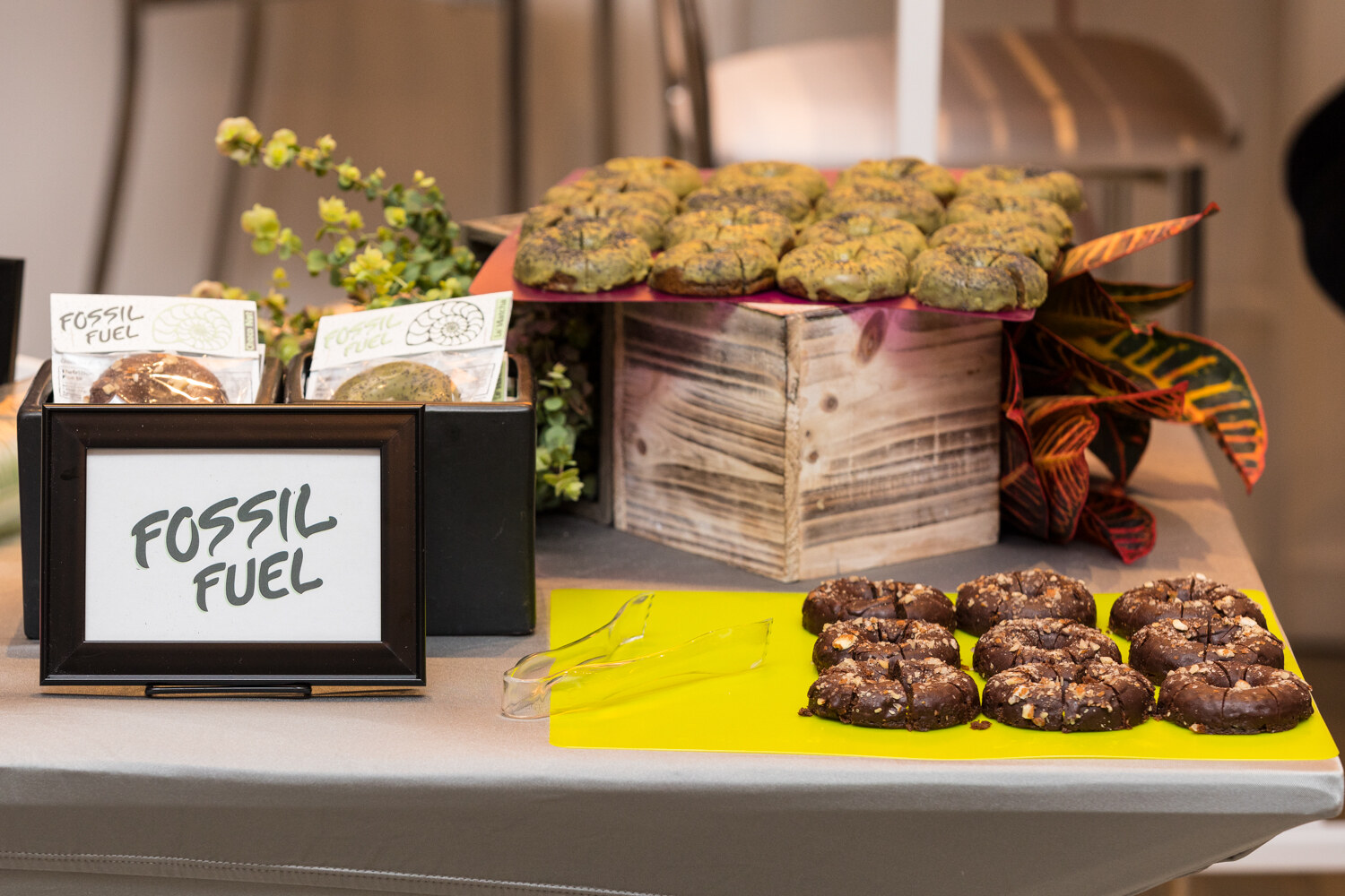 A sampling table of cookies and doughnuts with a hand-lettered Fossil Fuel sign.