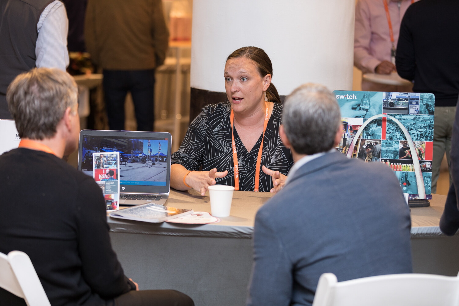 An expert at a Switch table talks with two attendees at the Sampling Experience and Expo.