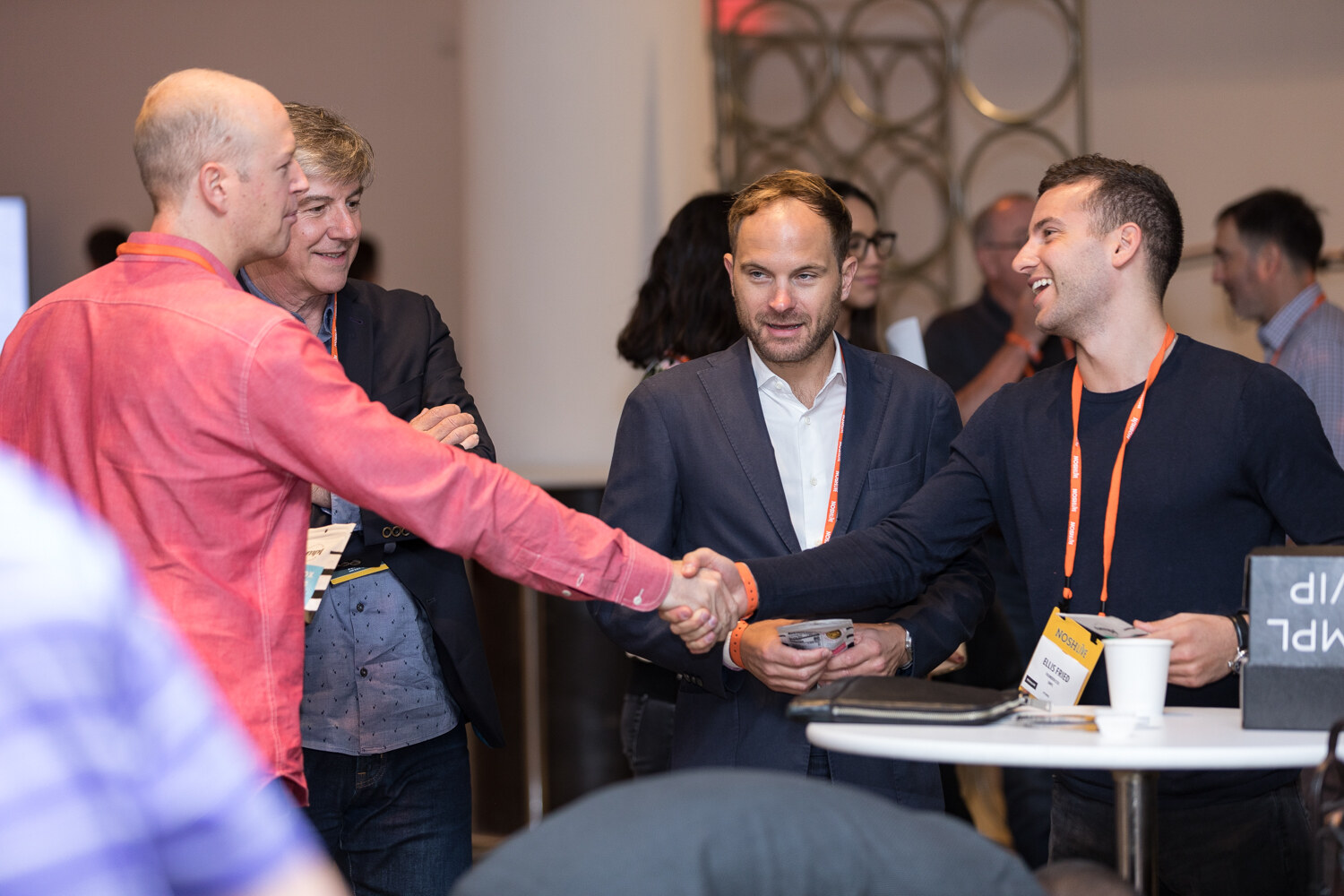 Attendees shaking hands at a high-top table