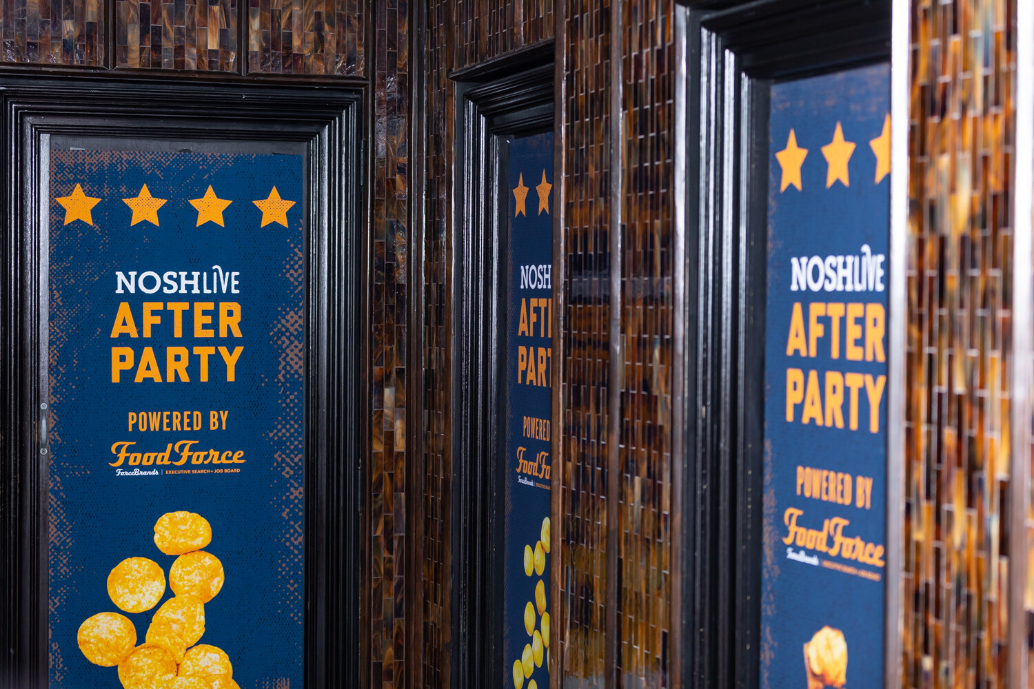 NOSHLIVE After Party powered by FoodForce banners in black frames on a mosaic-tiled wall