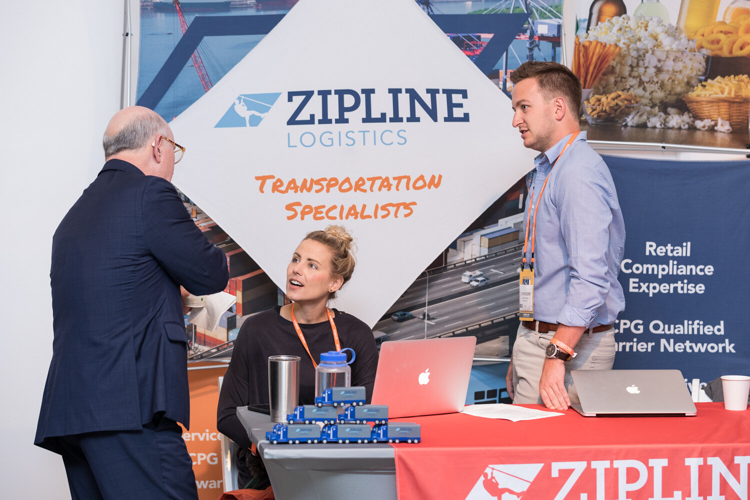 Visitor talking with a Zipline Logistics representative at the booth