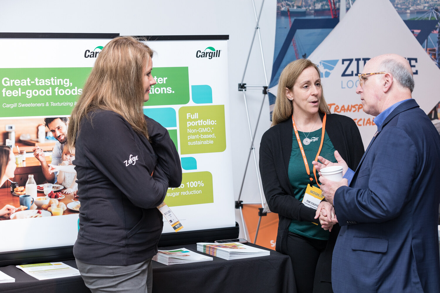Attendees talking in front of a Cargill banner