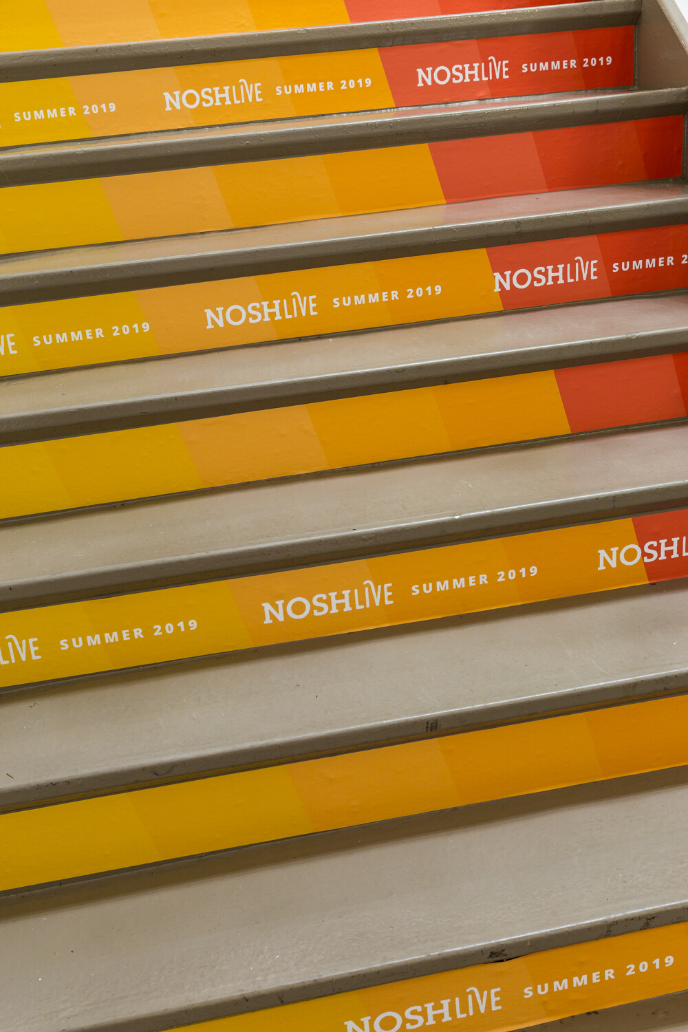 Staircase risers printed with NOSHLIVE Summer 2019 in orange and yellow