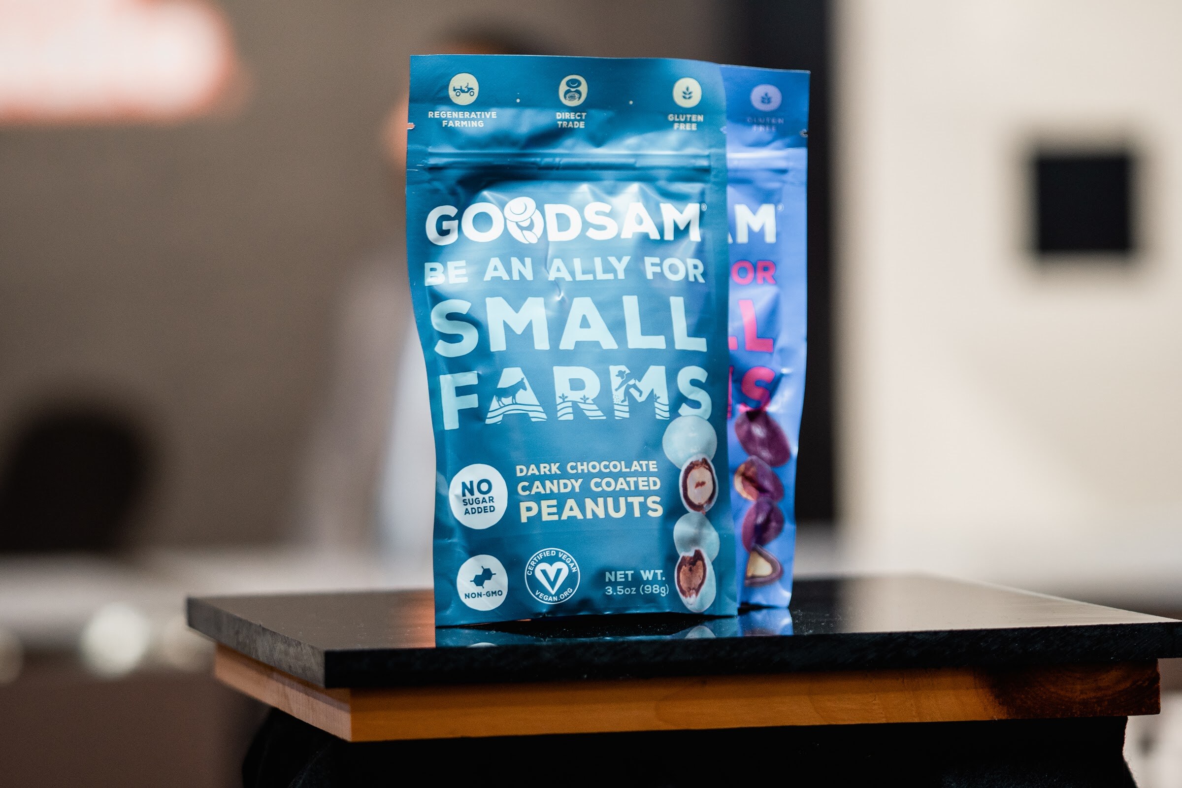 Blue Goodsam pouch reading Be an ally for small farms in front of a blurred set.