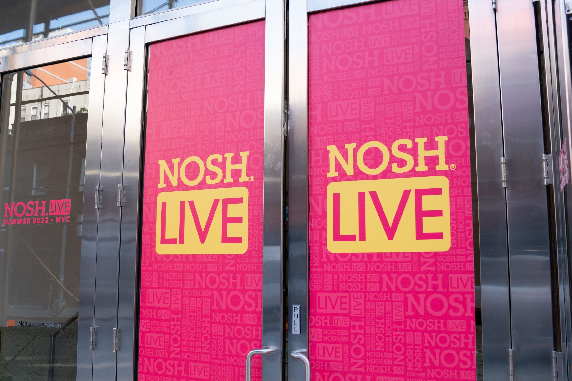 Two tall pink panels with the Nosh Live logo on stainless-steel doors.