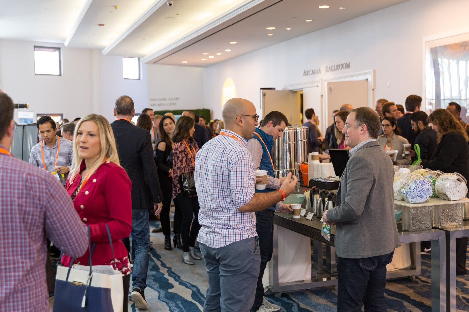 Attendees mingle around a coffee station during the networking break.