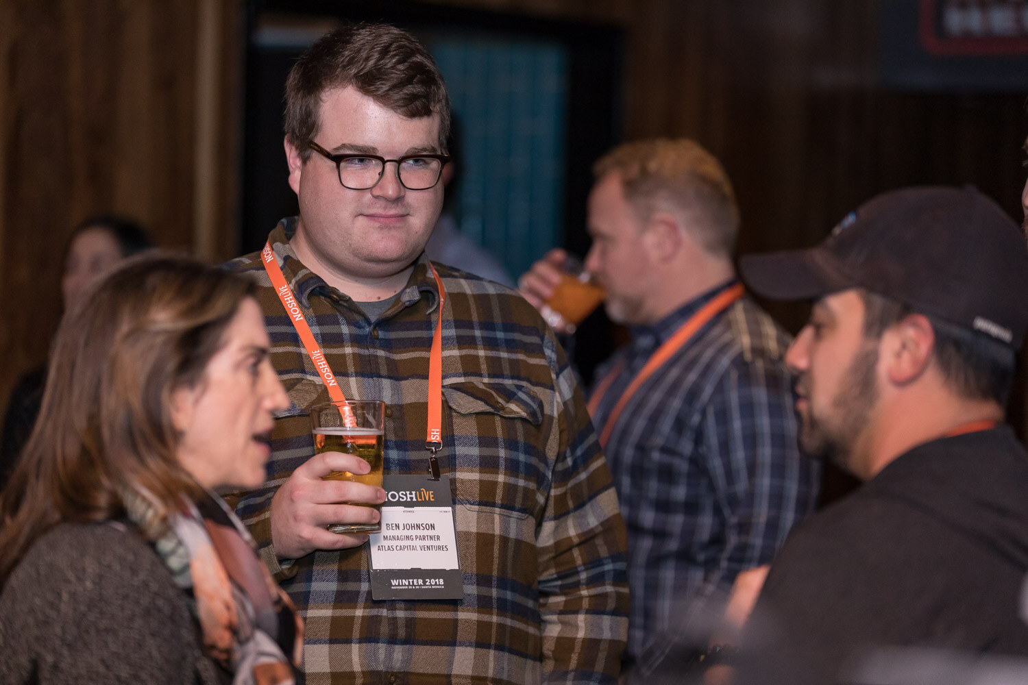 Attendees talk and hold drinks at the afterparty.