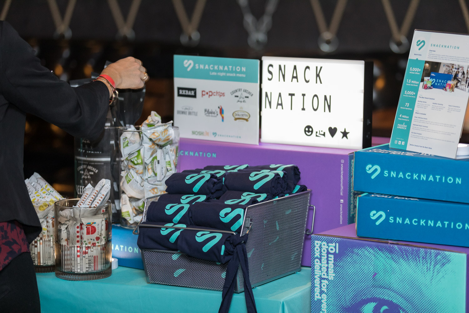 A Snacknation table with branded socks and boxes at the afterparty.