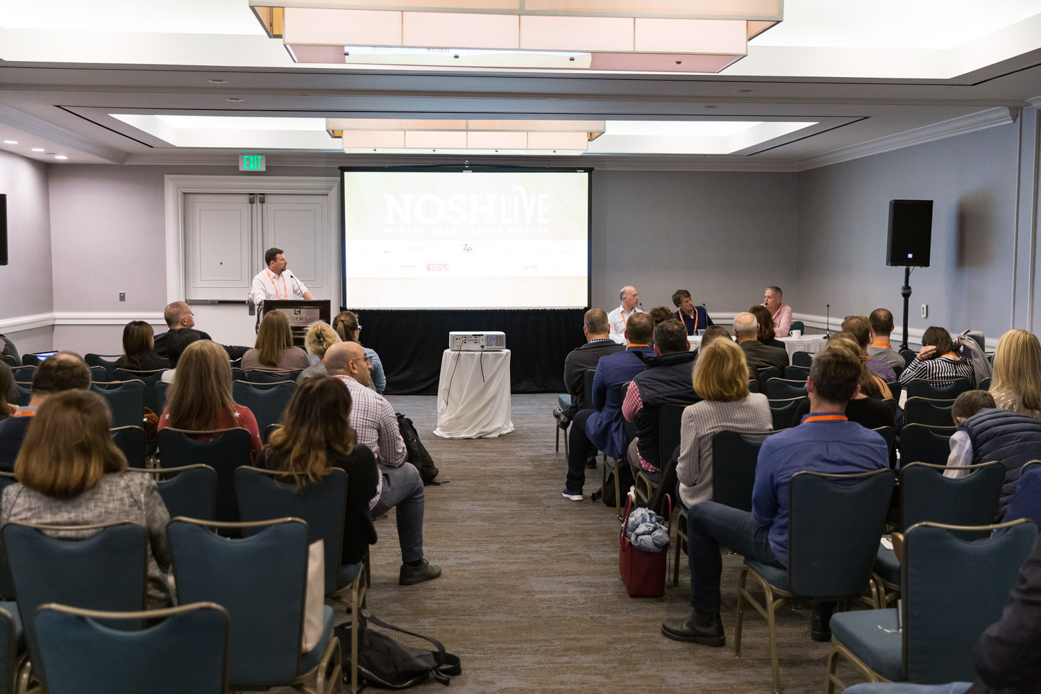 A speaker presents to a seated audience in a breakout room at the Loews Santa Monica Beach Hotel during Breakout Session 1.