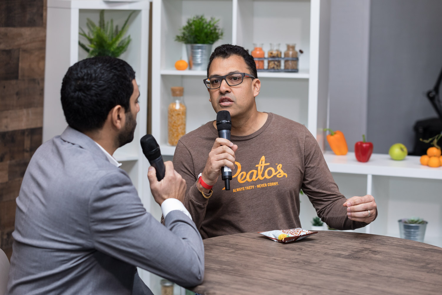 A host interviews a man in a brown Peatos shirt in the livestream studio.