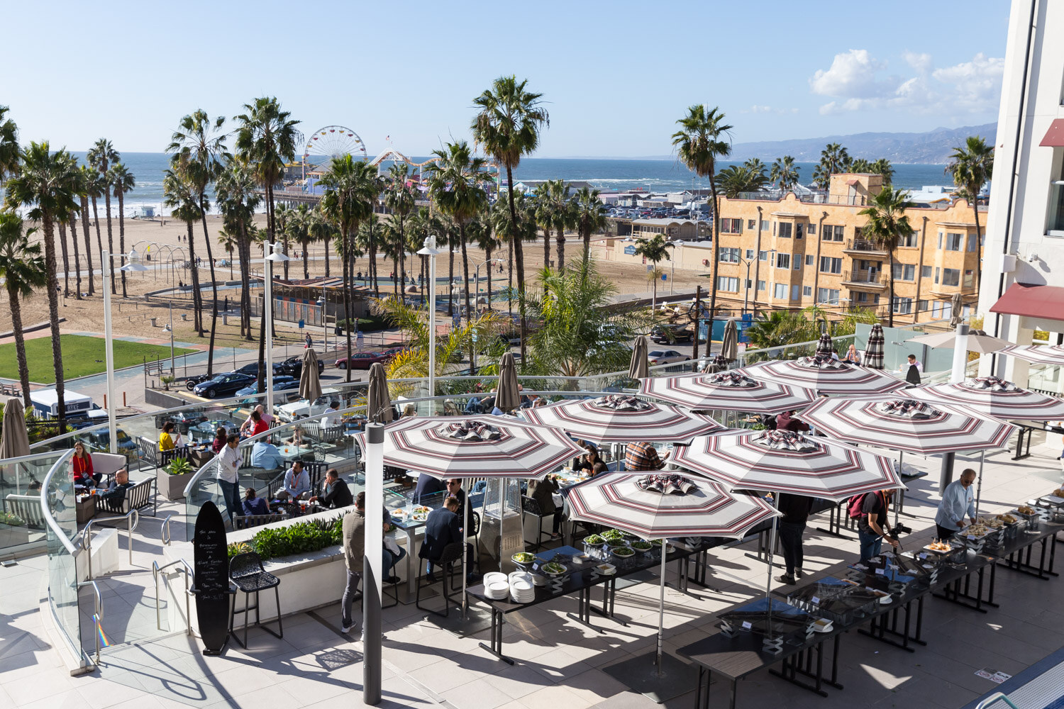Umbrellas and tables on the hotel terrace overlooking the Santa Monica beach.