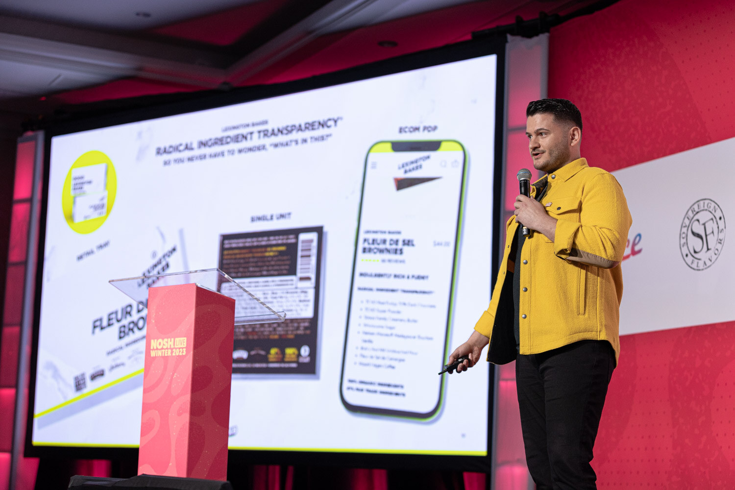 A man in a yellow jacket beside a large screen showing Radical Ingredient Transparency and a Fleur de Sel Brownies product page.