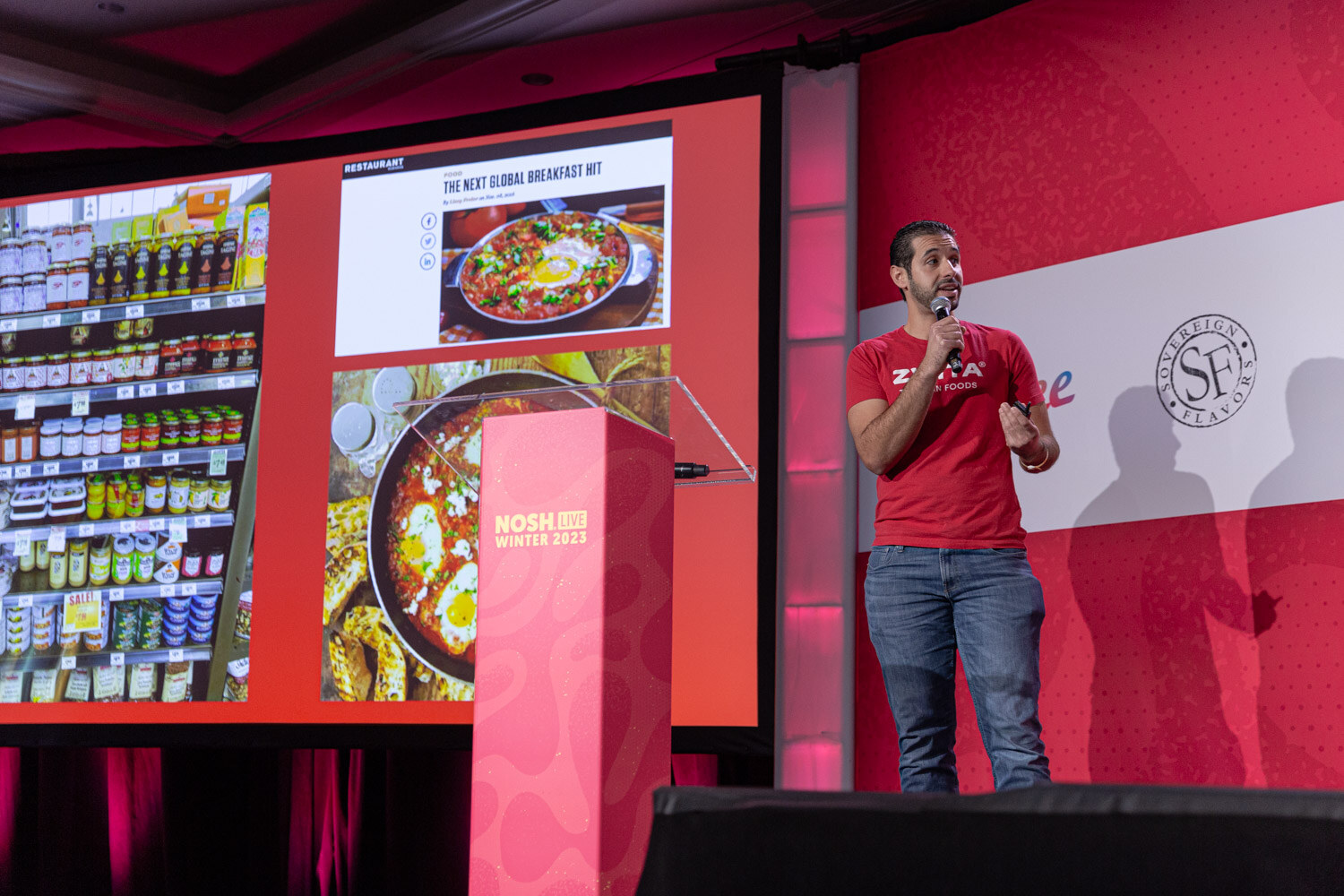 A man in a red Zwita shirt at a podium beside a slide reading Real Tunisian food.