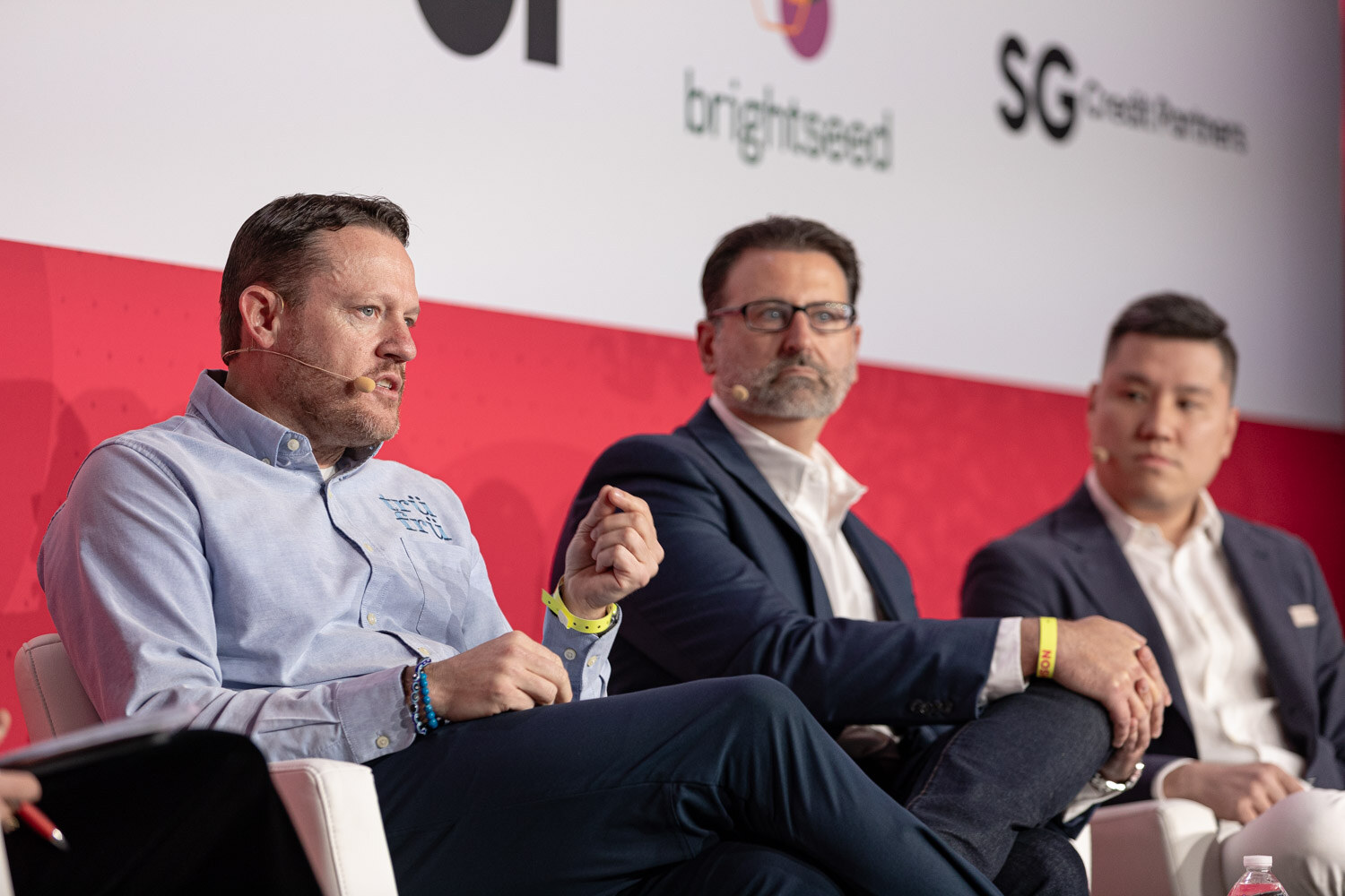 Three men seated on stage with logos for brightseed and SG Credit Partners behind them.