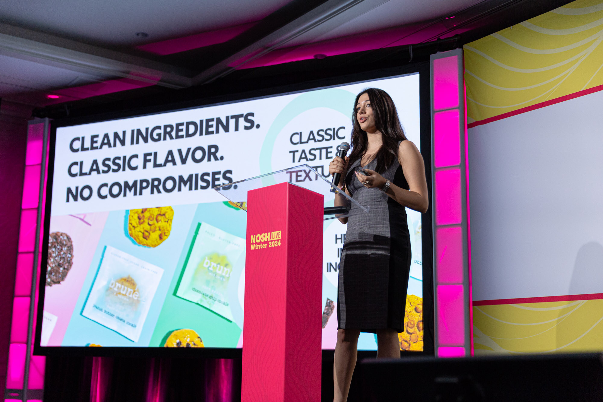 Wide view of a stage with a large screen reading Clean Ingredients. Classic Flavor. No Compromises. and judges seated at right.