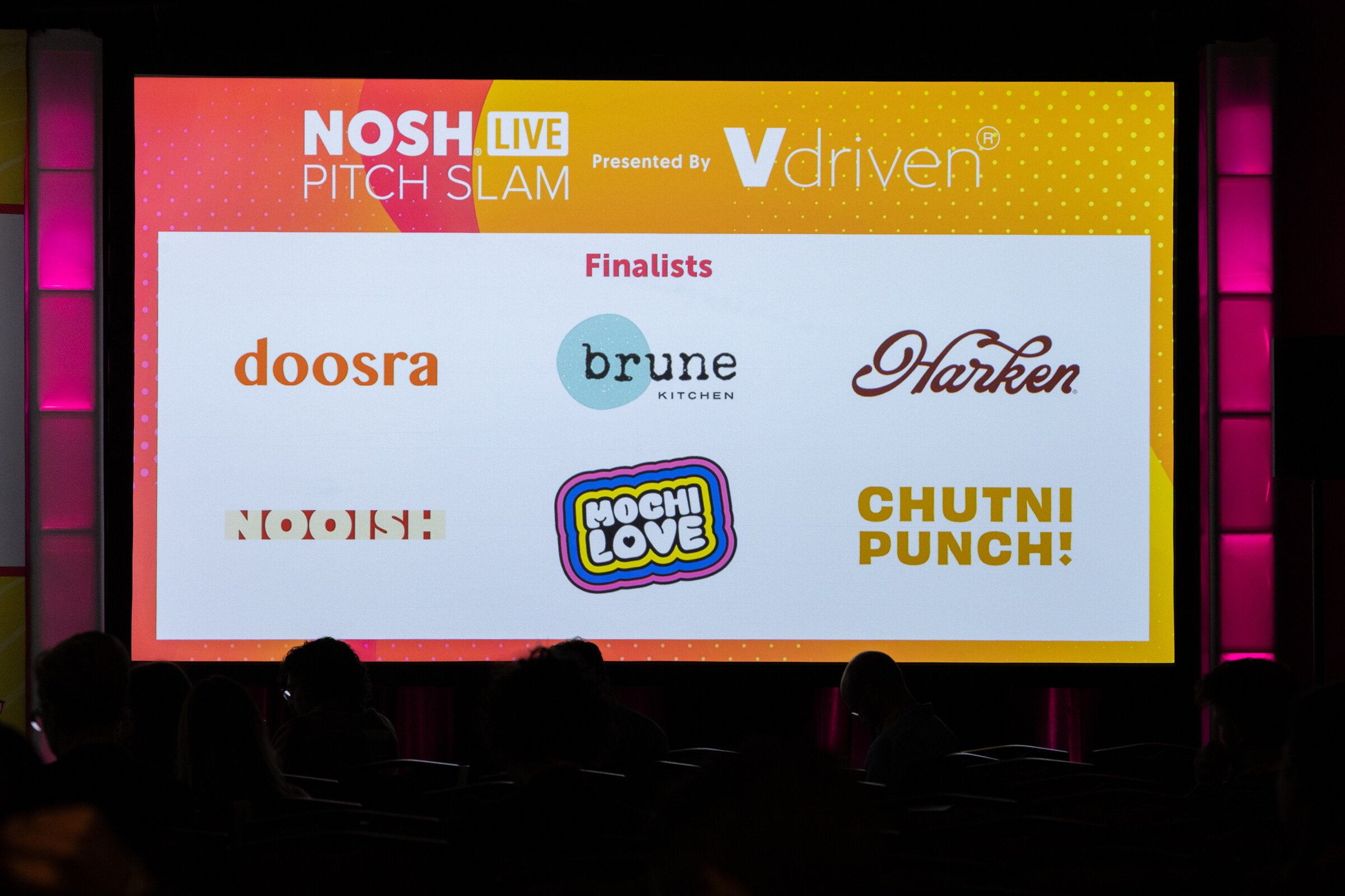 A large screen reading Pitch Slam Finalists with six brand logos.