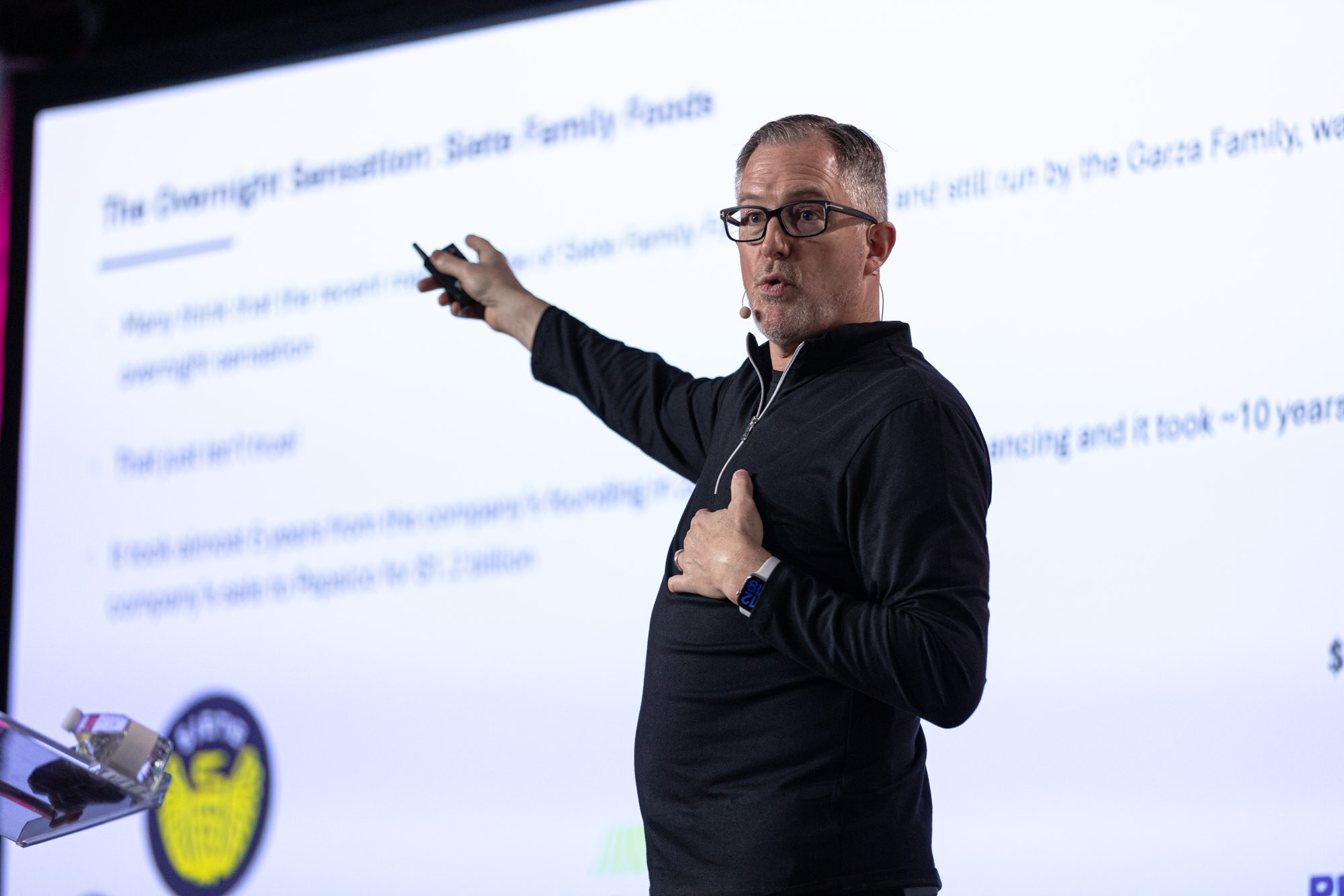 A man in a black quarter-zip pointing at a slide titled The Overnight Sensation: Siete Family Foods.