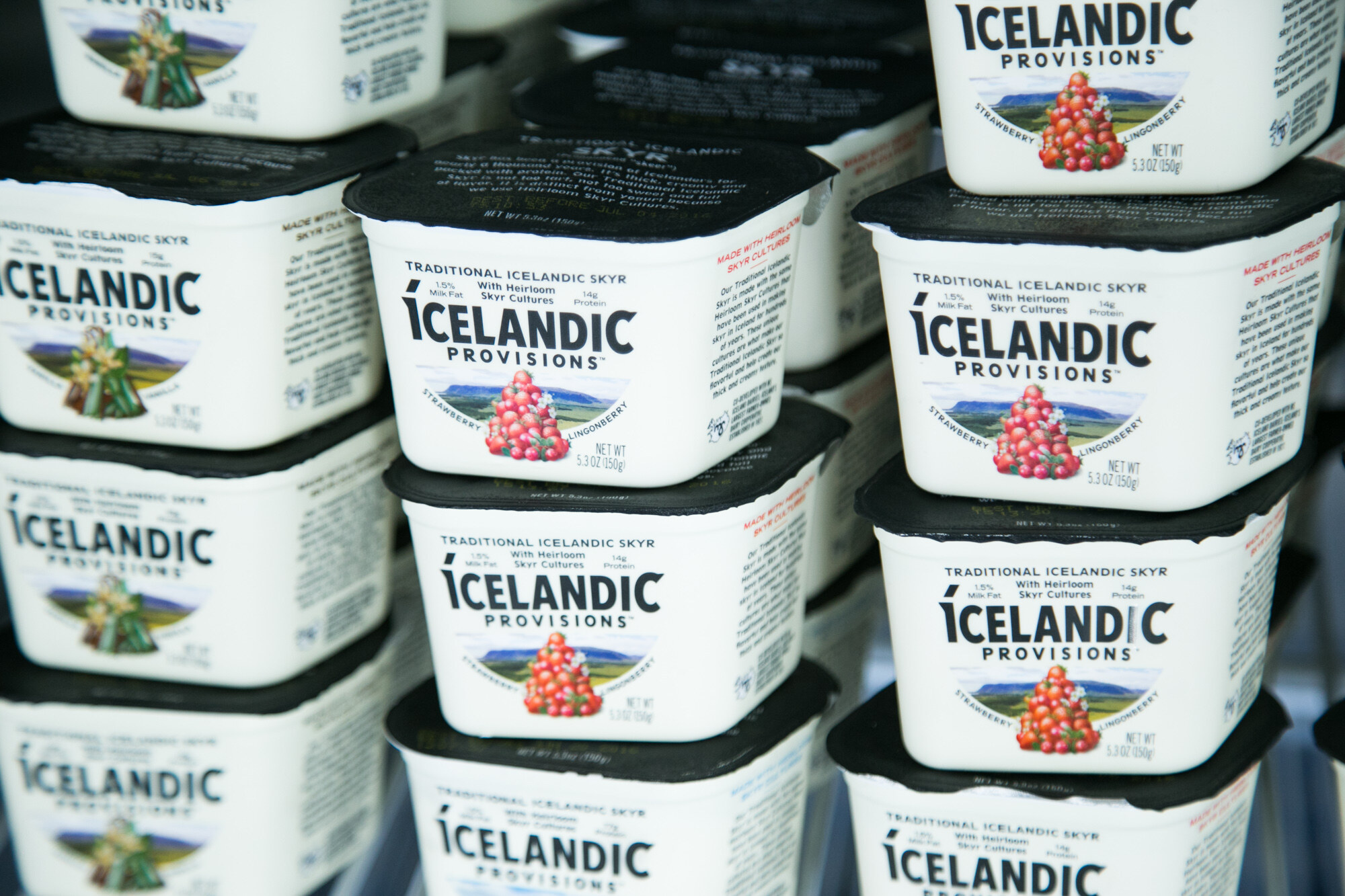 Close view of stacked white and black cups labeled Icelandic Provisions Traditional Icelandic Skyr.